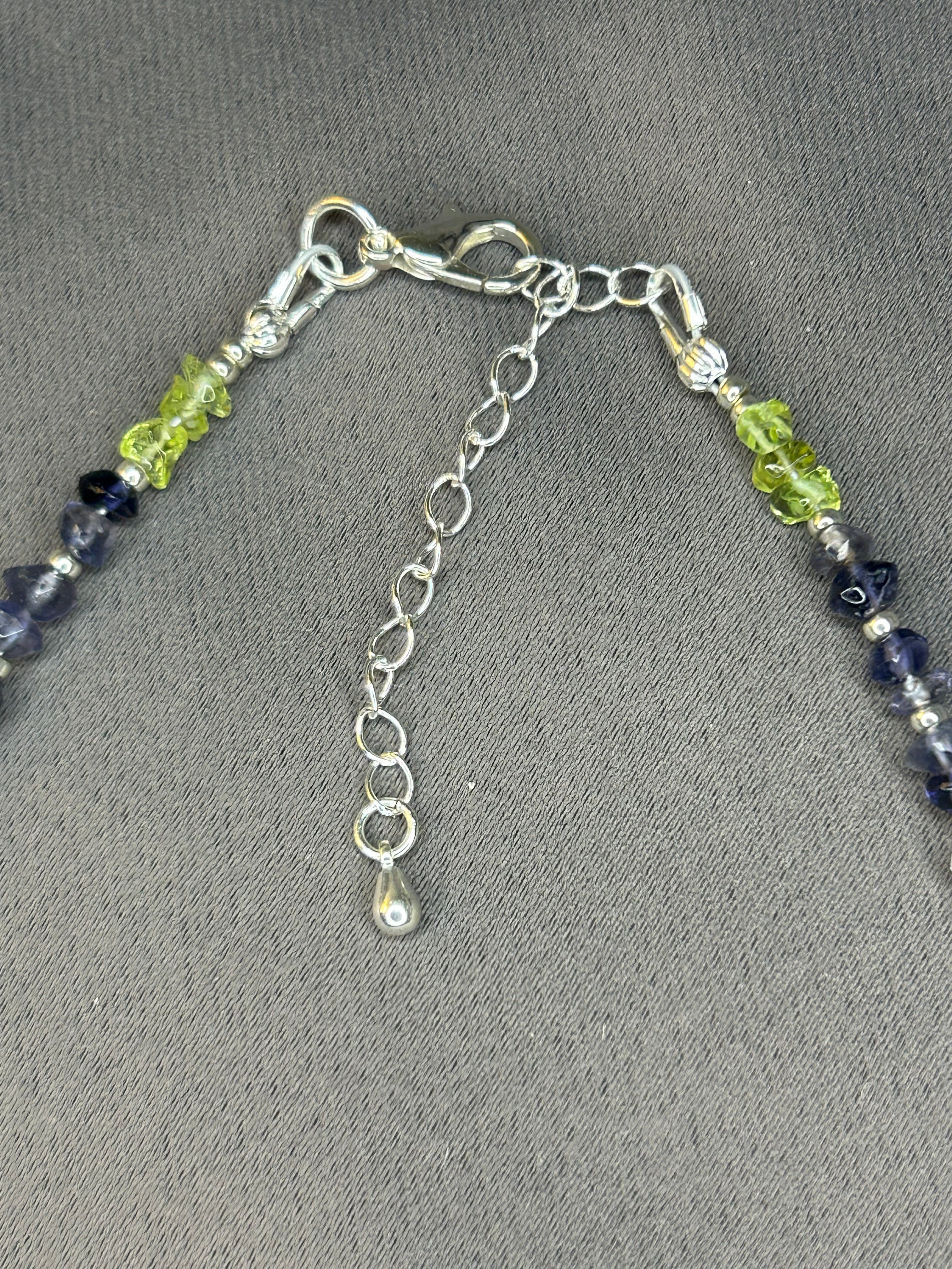 Necklace with green and blue beads on a gray background