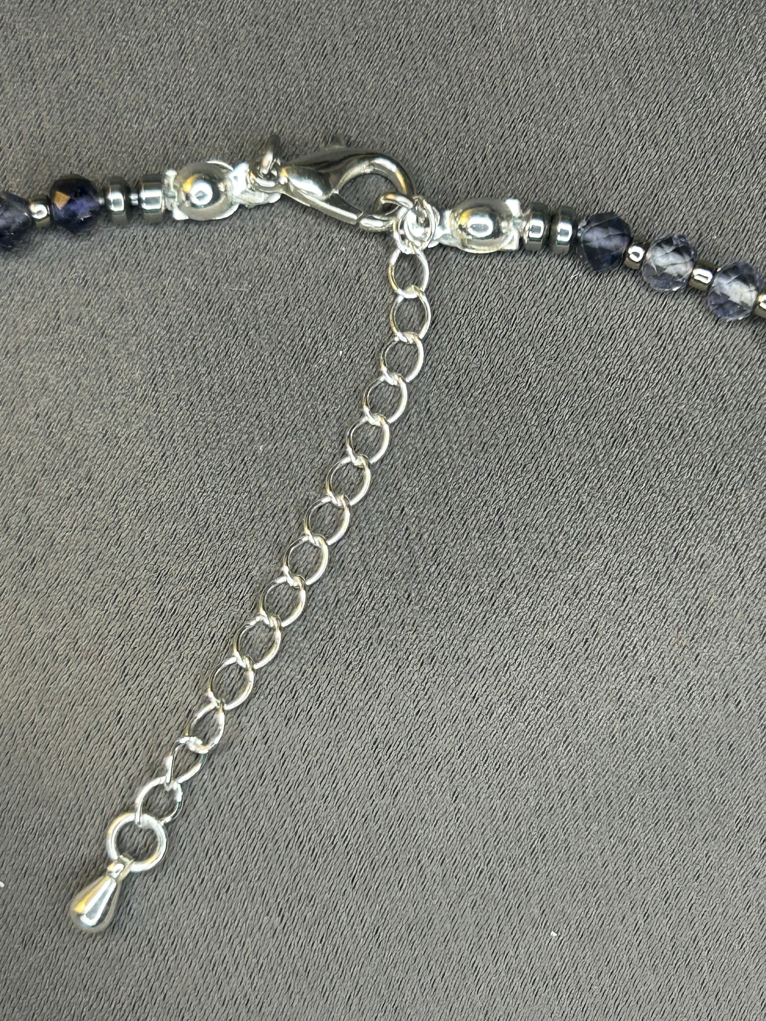 Necklace with blue beads and silver chain on a gray background
