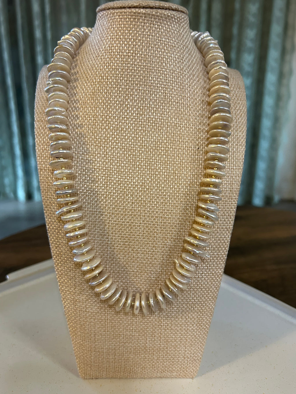 White pearl rondelle necklace on a mannequin bust. 