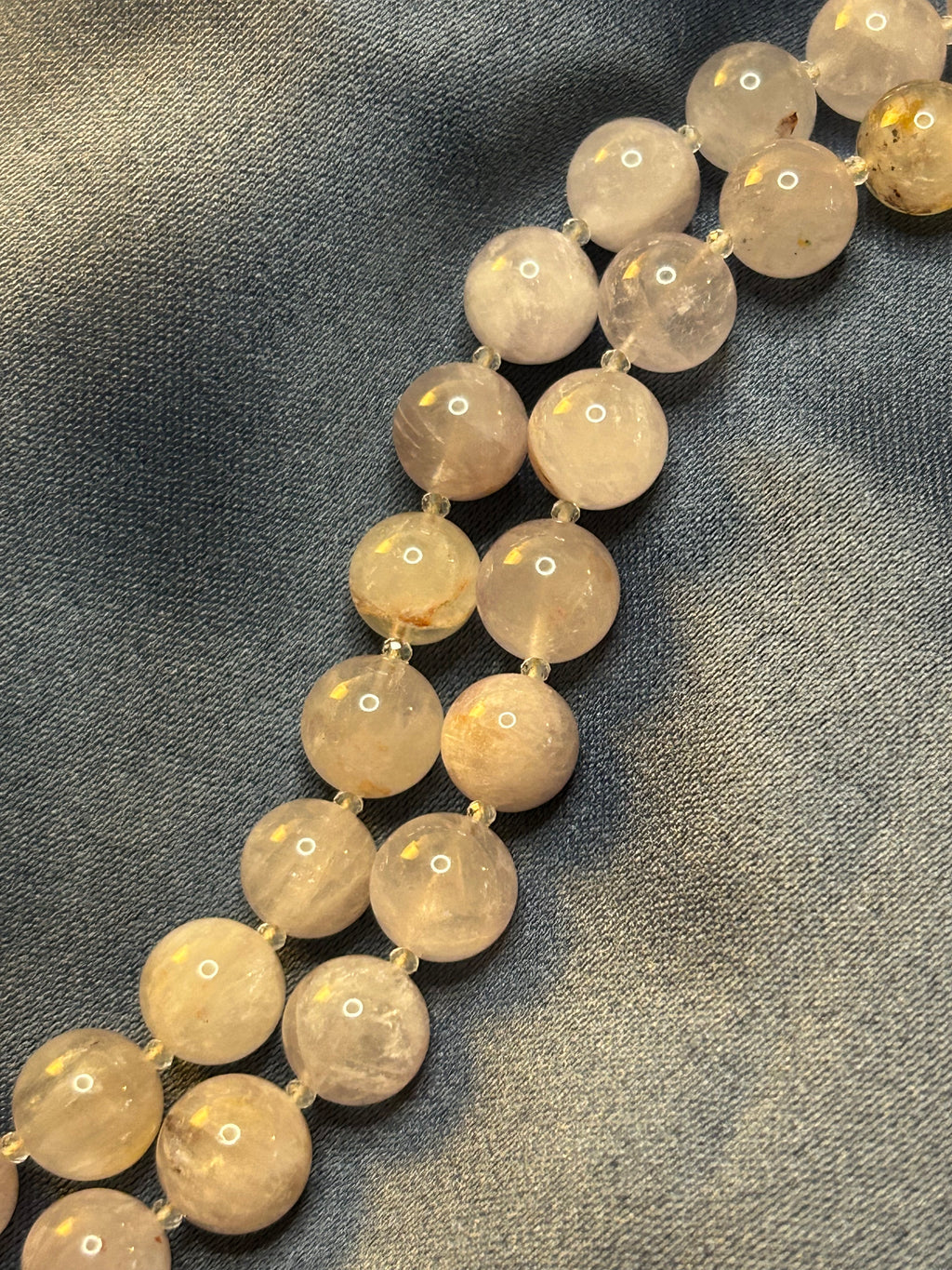 Necklace with light-colored beads on a textured gray background