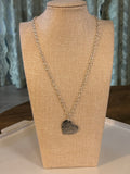 Necklace with a heart-shaped pendant on a mannequin bust.