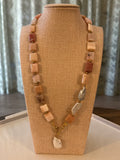 Necklace with square beads on a beige stand