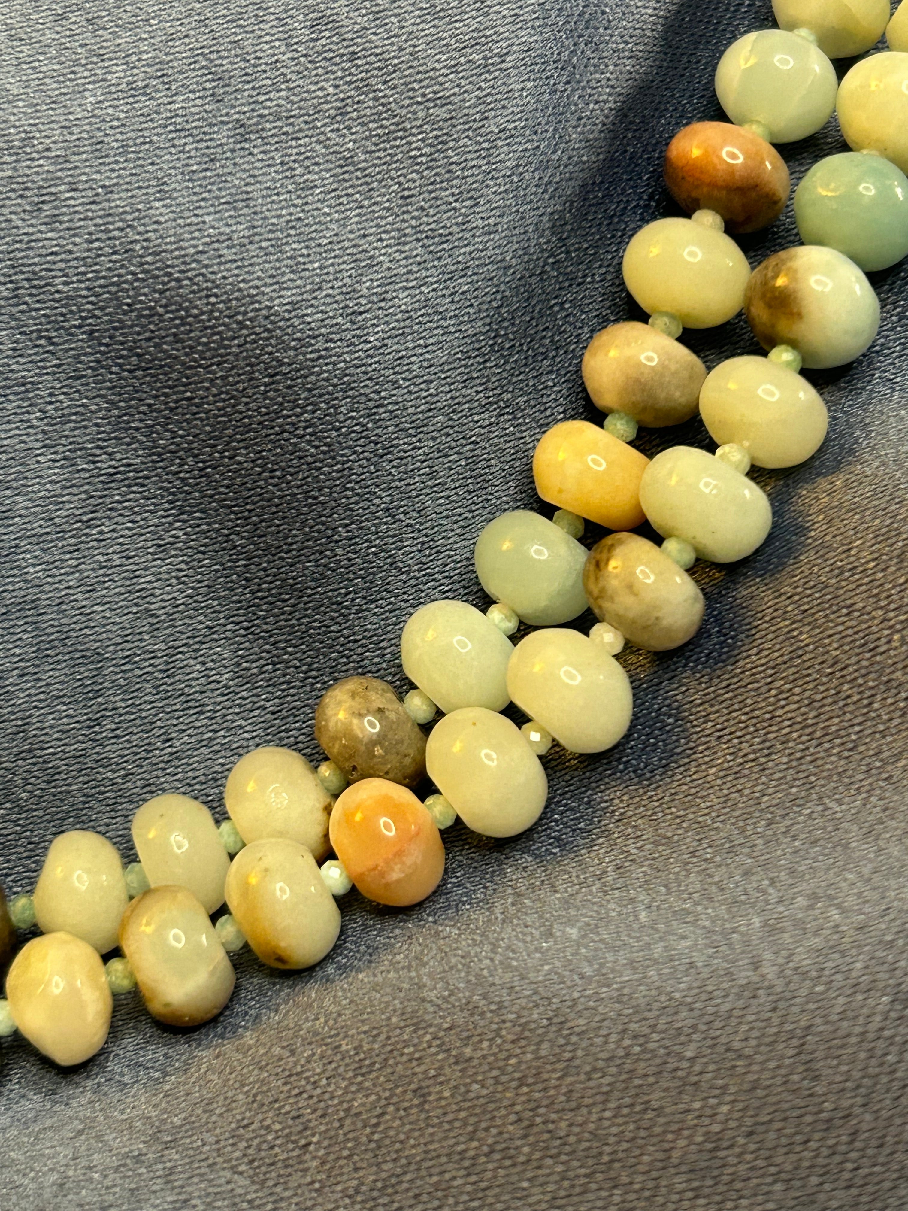 Necklace with multicolored beads on a gray fabric background