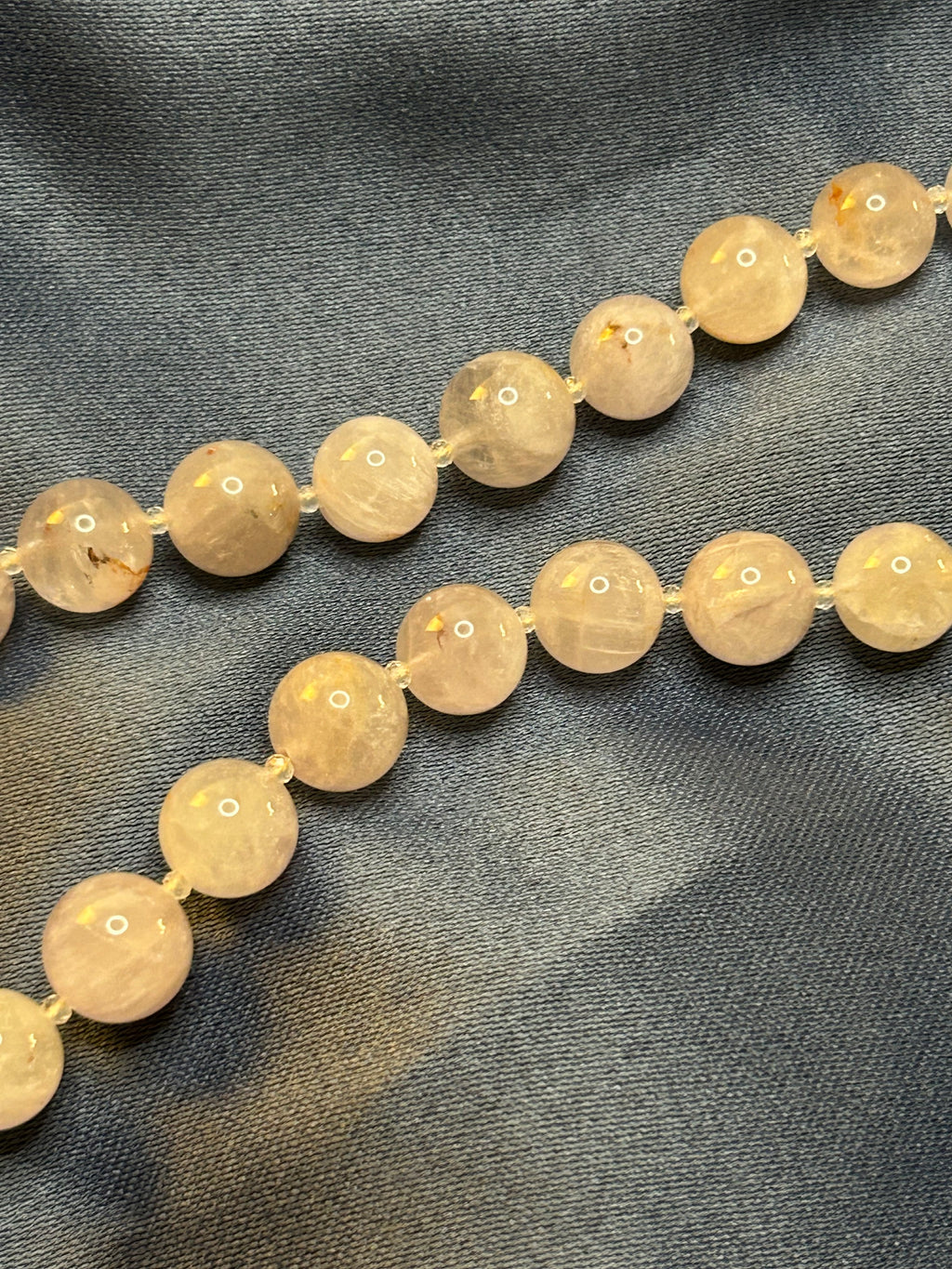 Necklace with purple beads on a dark fabric background