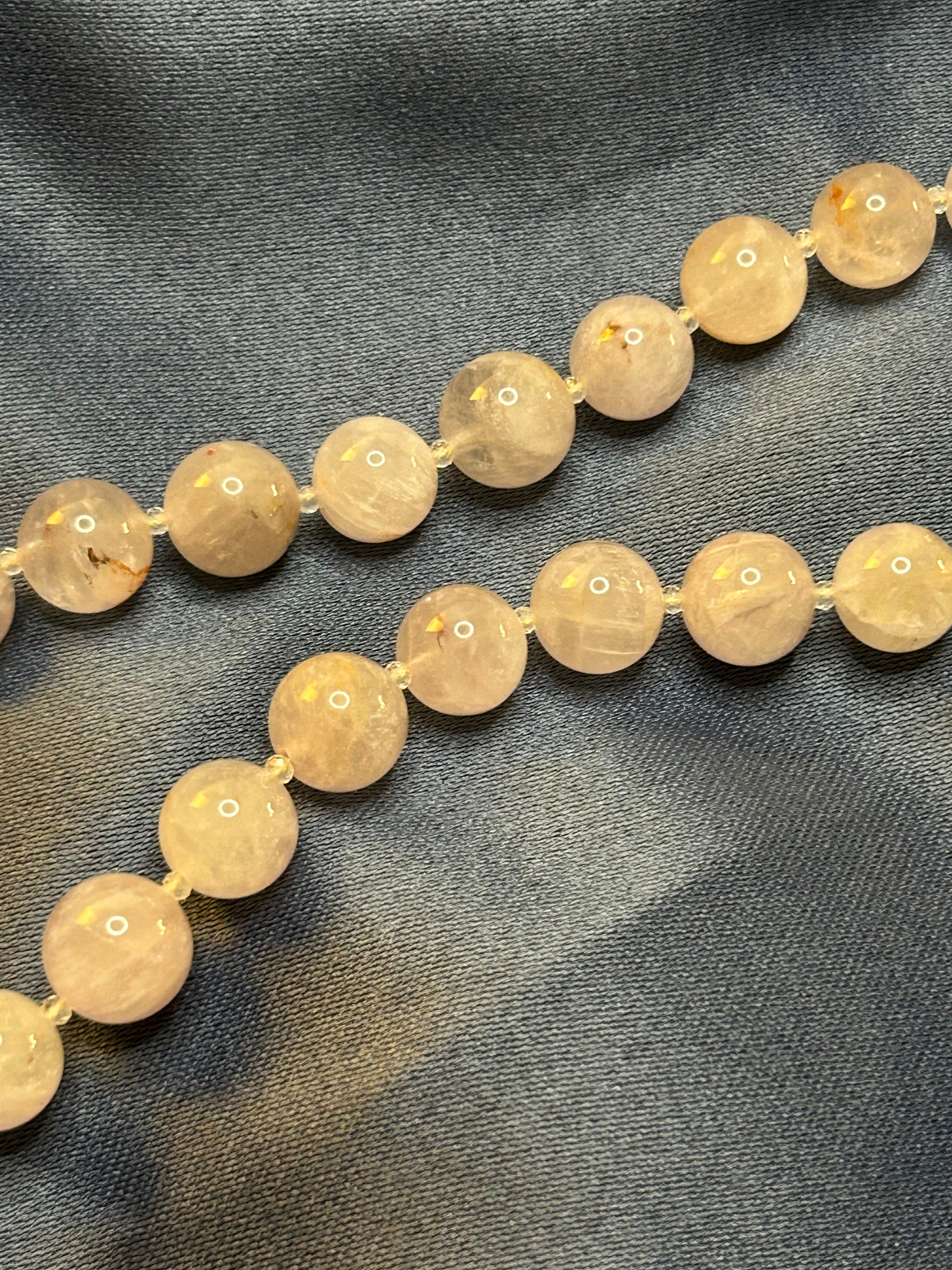 Necklace with purple beads on a dark fabric background