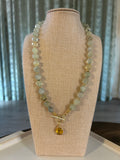 Necklace with green beads on a beige display stand