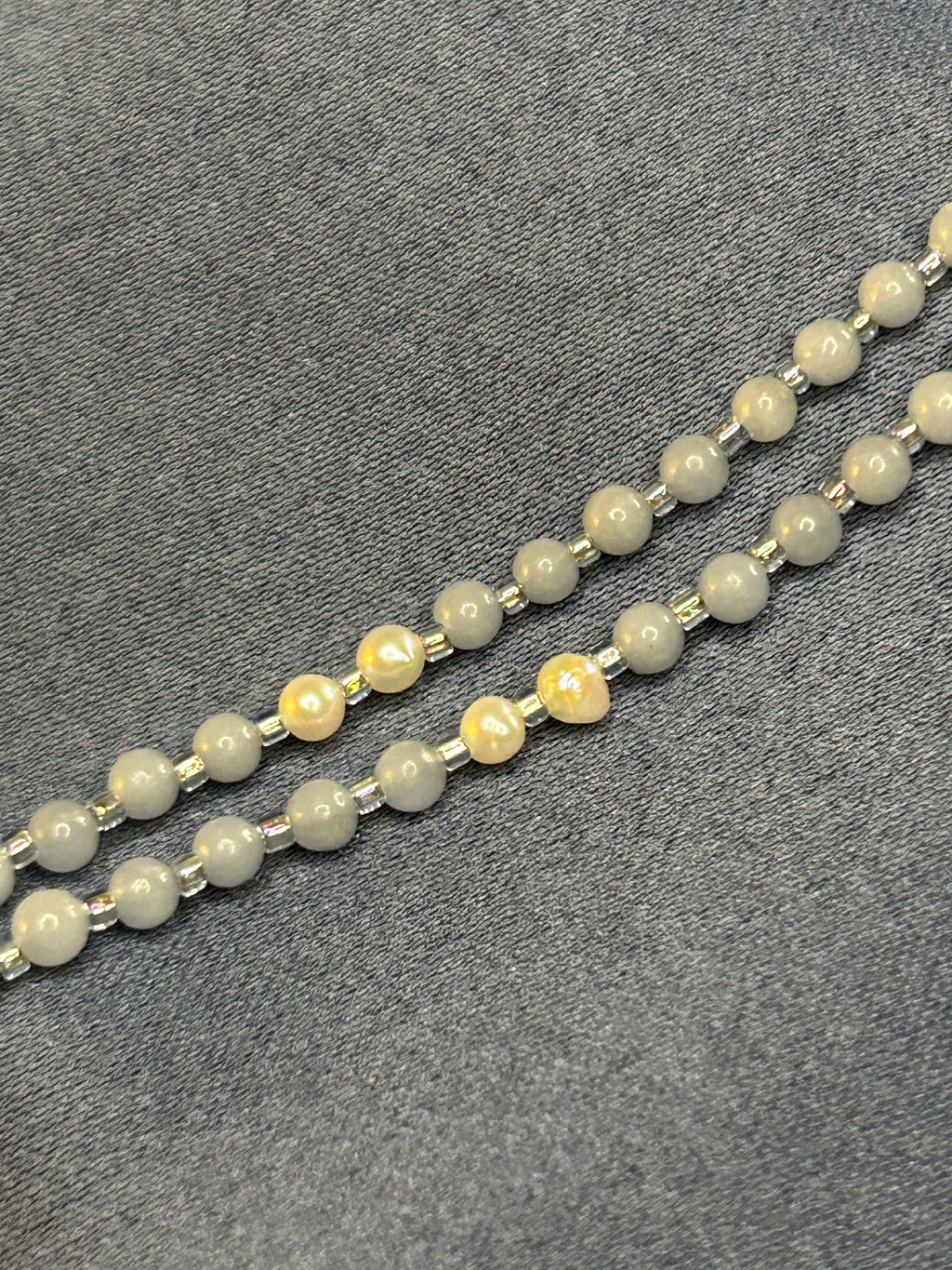 Necklace with blue beads on a gray fabric background