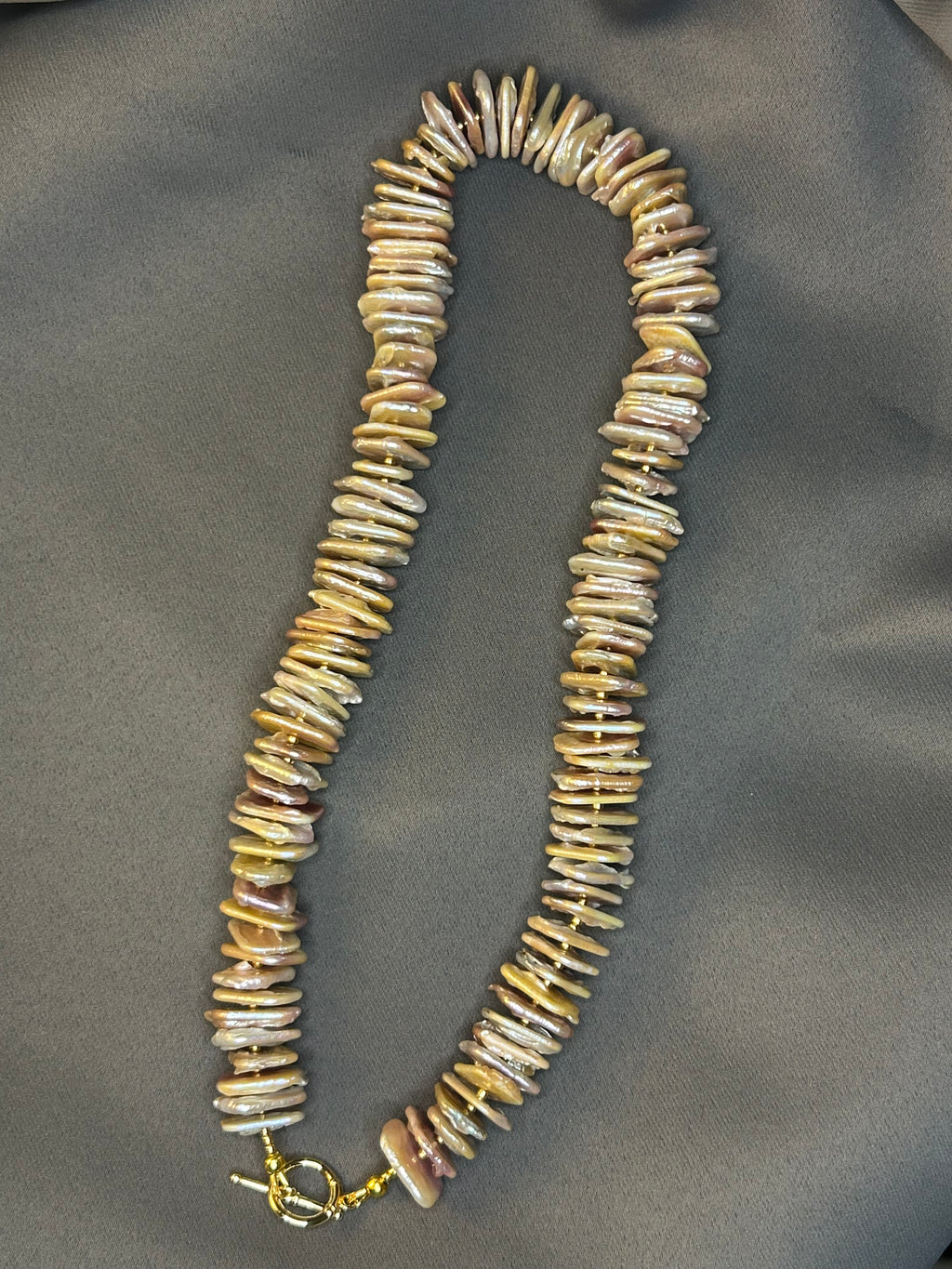 Necklace with shell-like beads on a gray background