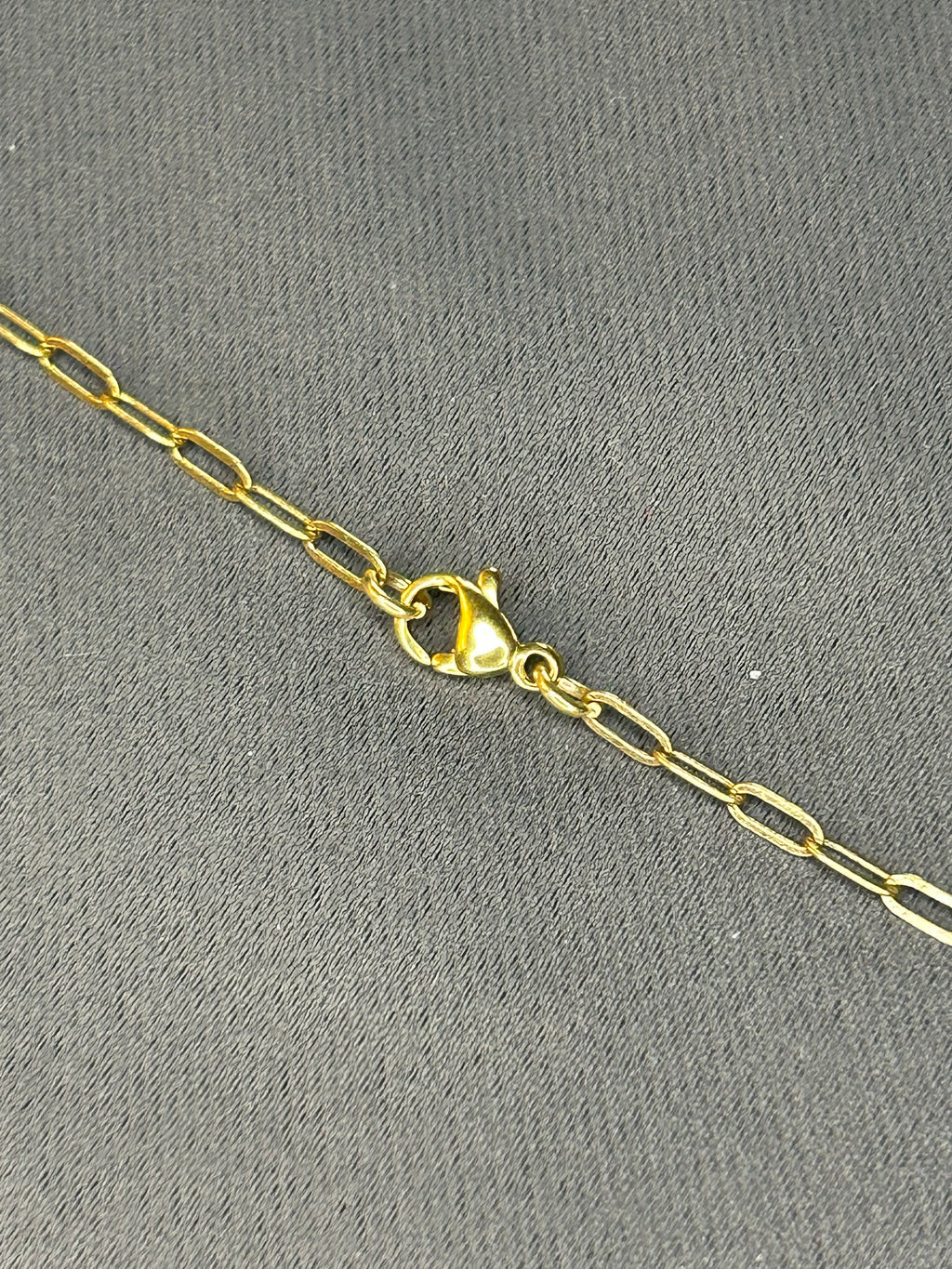 Gold chain necklace on a gray textured background
