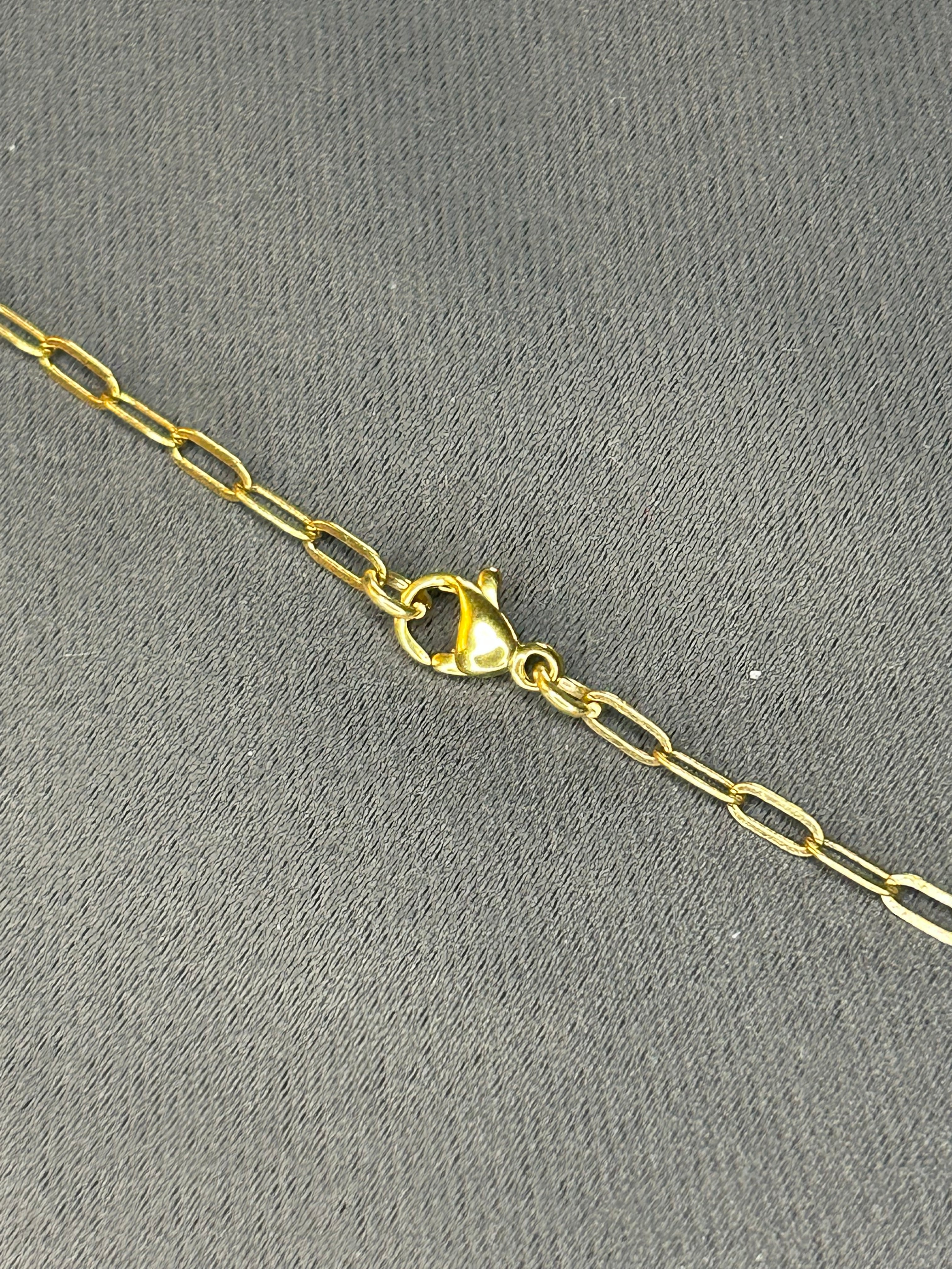Gold chain necklace on a gray textured background