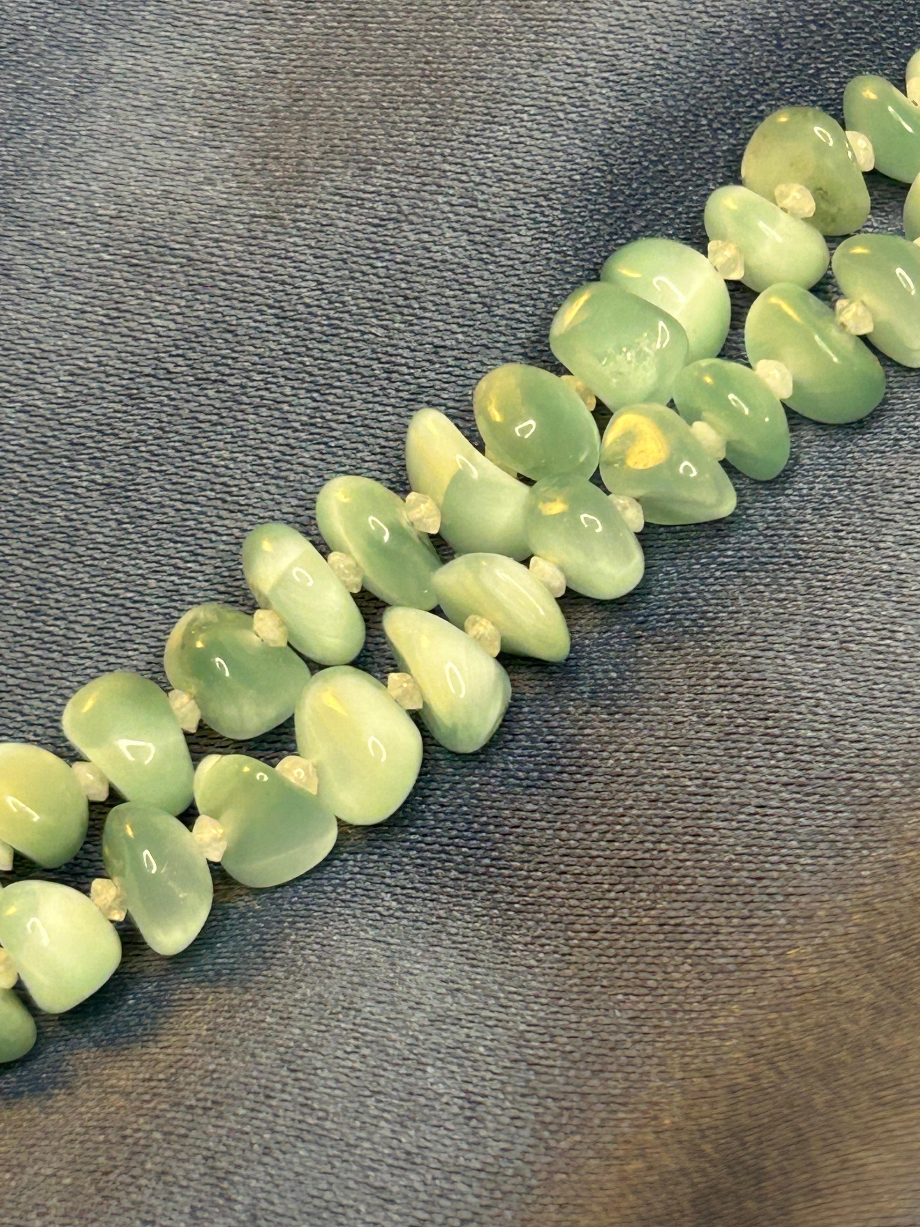 Necklace with green beads on a textured gray background