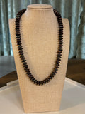 Brown pearl rondelle necklace on a beige mannequin bust against a neutral background