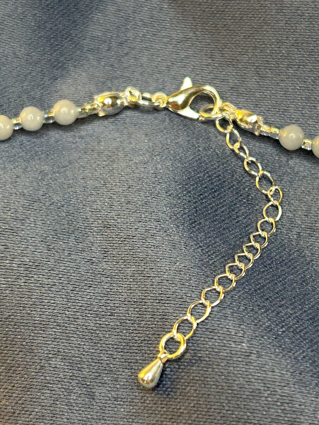 Necklace with beads and silver chain on a gray background