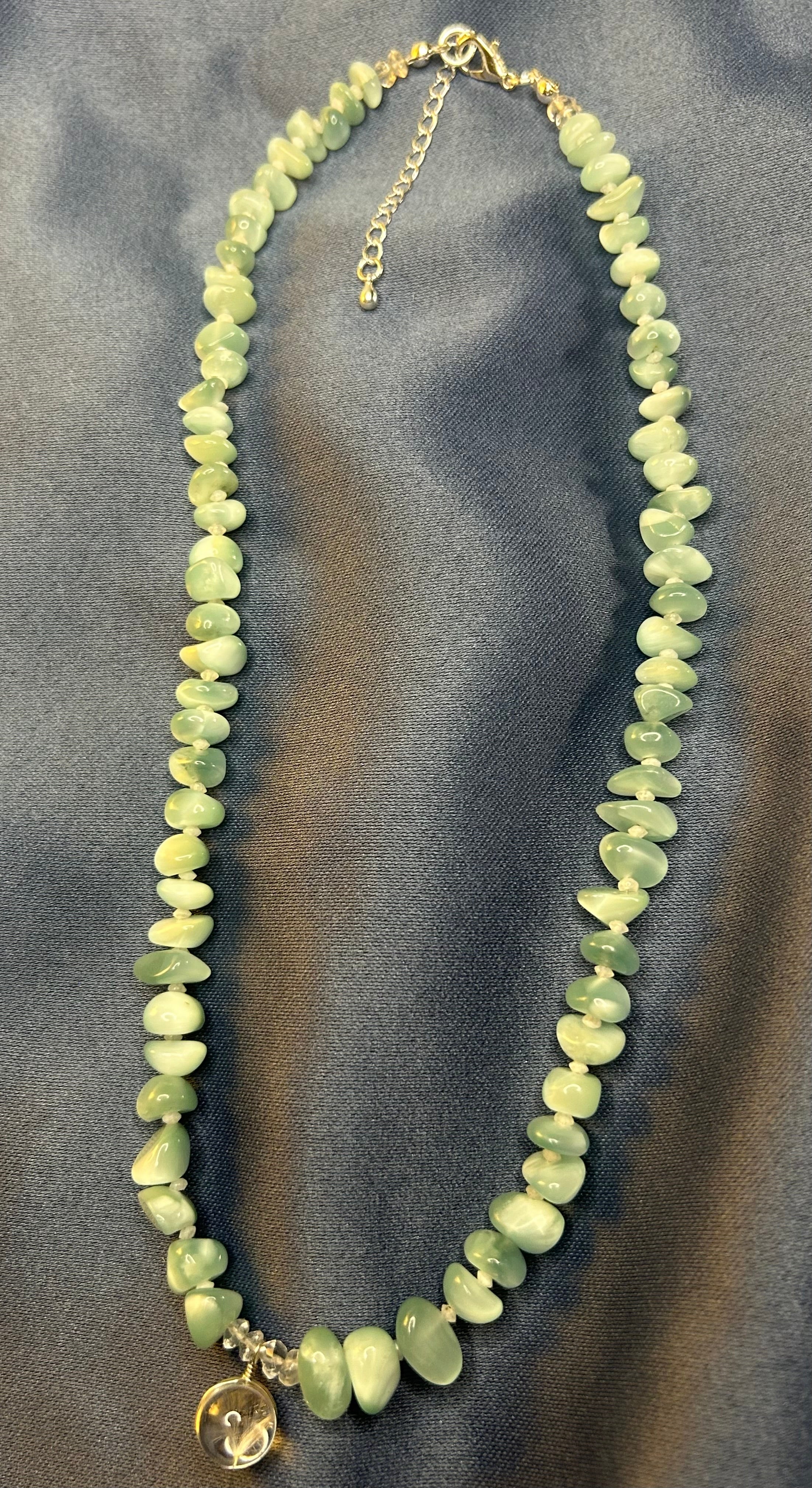 Necklace with green beads on a gray background