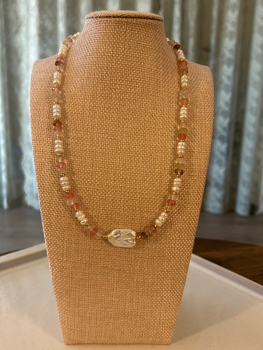 Beaded necklace on a brown jewelry display