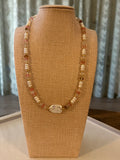 Beaded necklace on a brown jewelry display