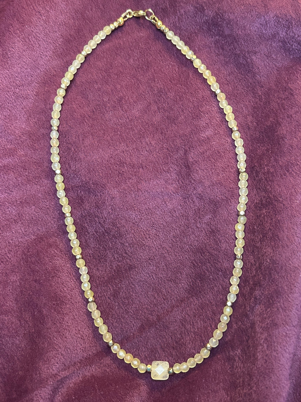 Necklace with small beads on a purple textured surface