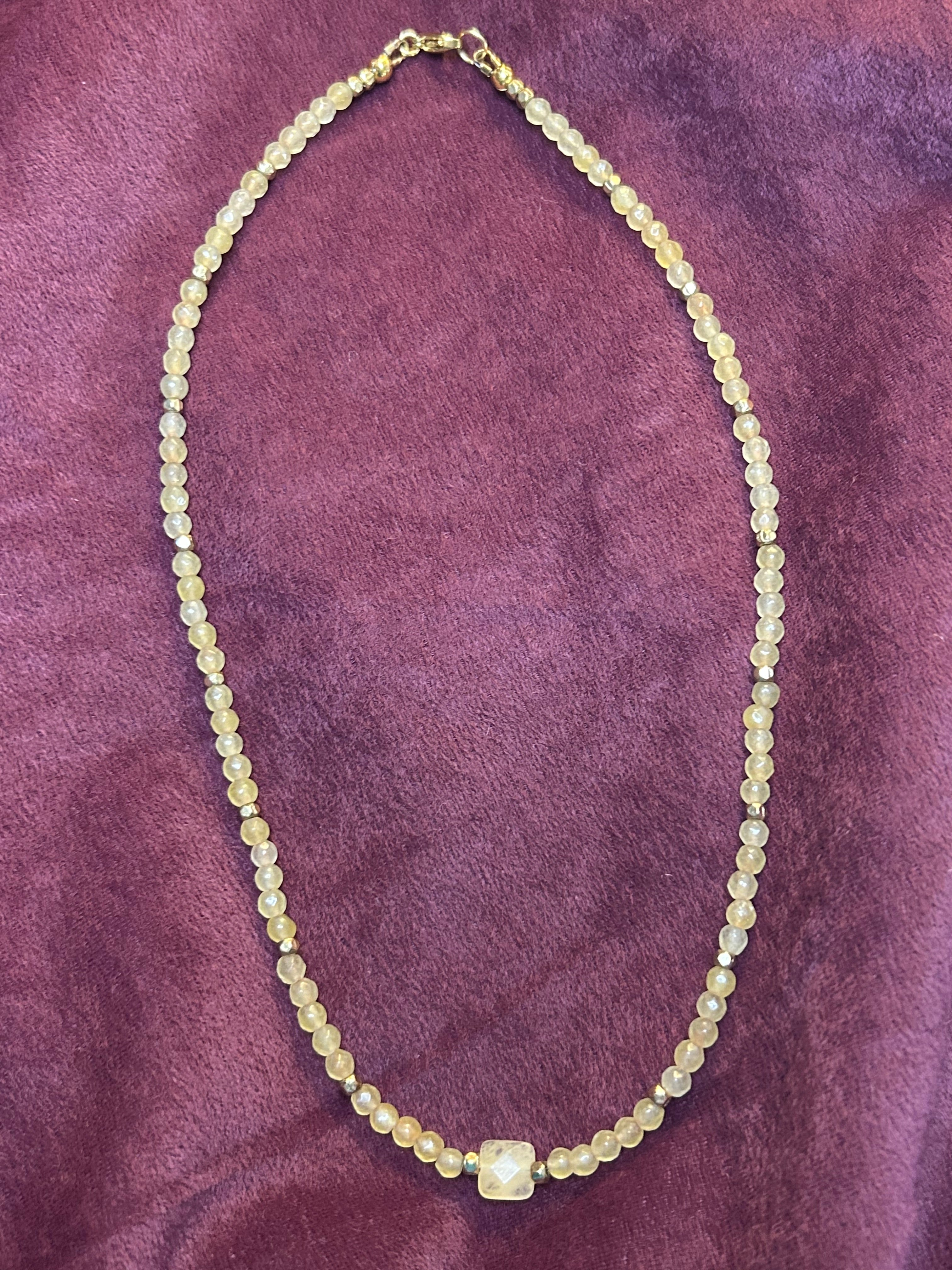 Necklace with small beads on a purple textured surface