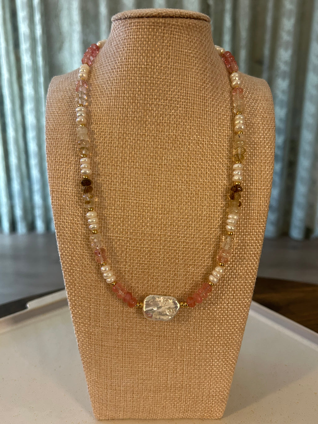 Beaded necklace on a mannequin bust with a neutral background