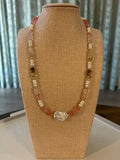 Beaded necklace on a mannequin bust with a neutral background