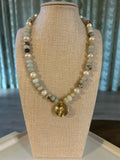 Beaded bracelet on a mannequin bust with a neutral background