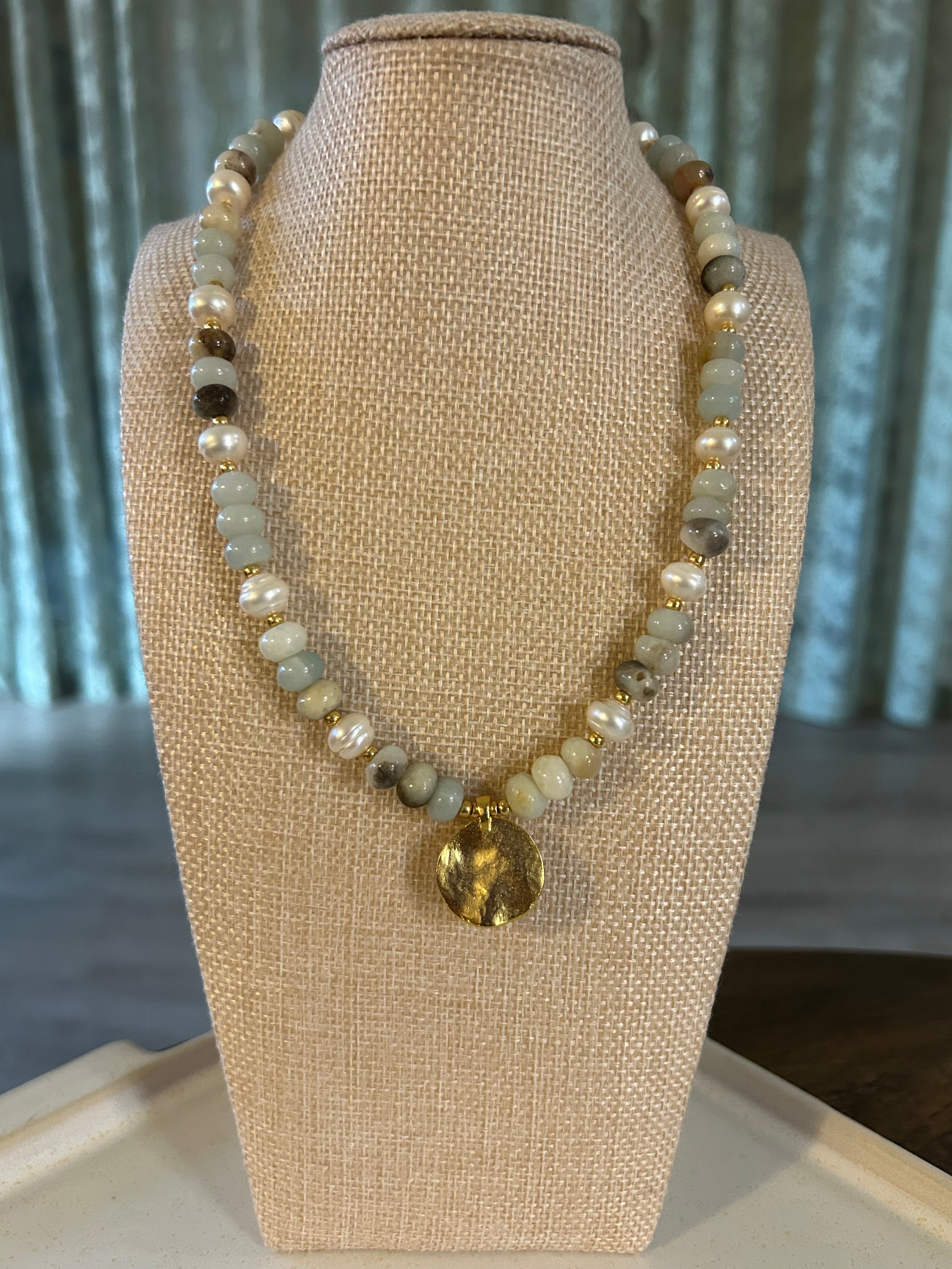 Beaded bracelet on a mannequin bust with a neutral background