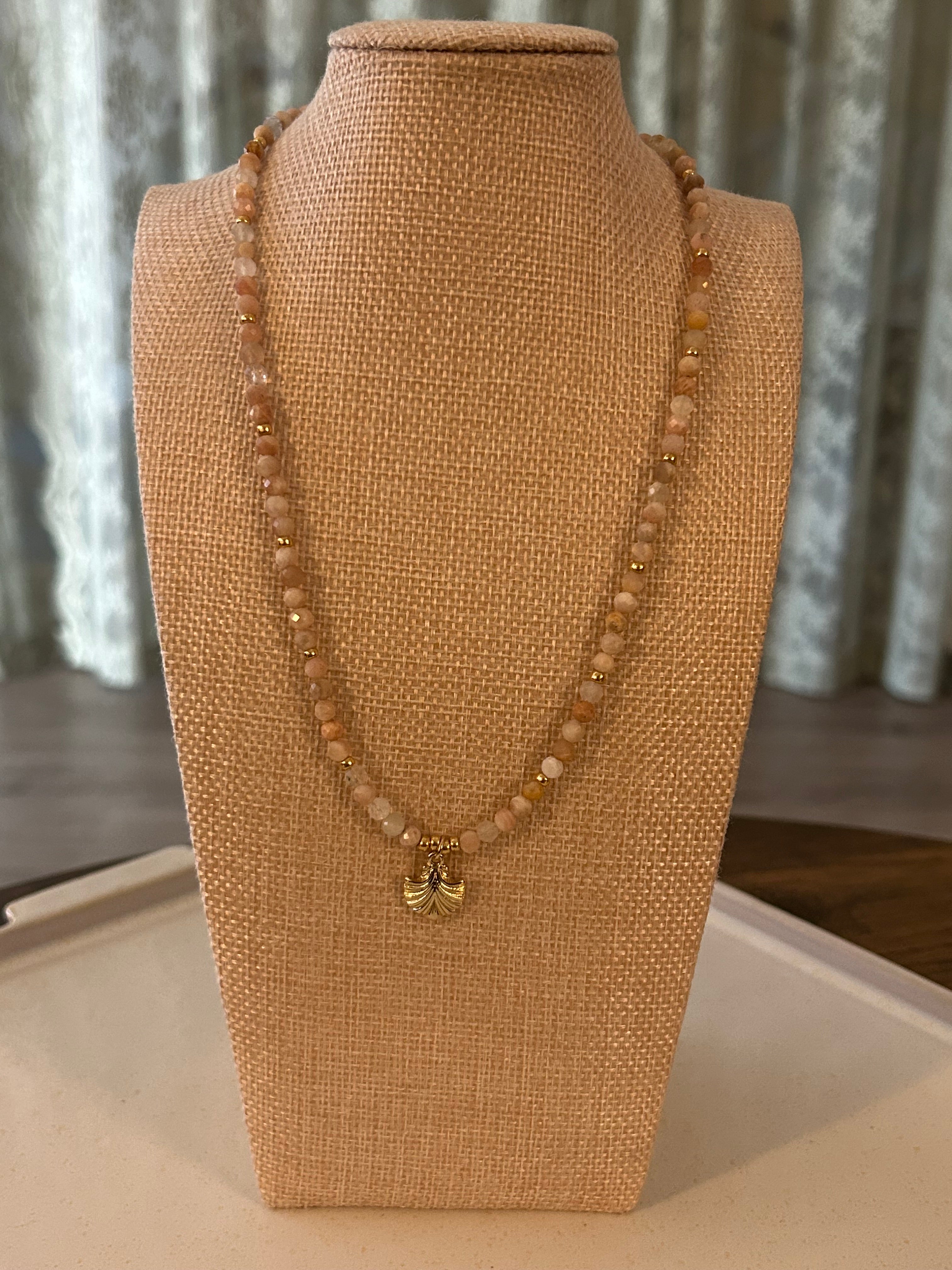 Beaded necklace on a mannequin bust with a neutral background