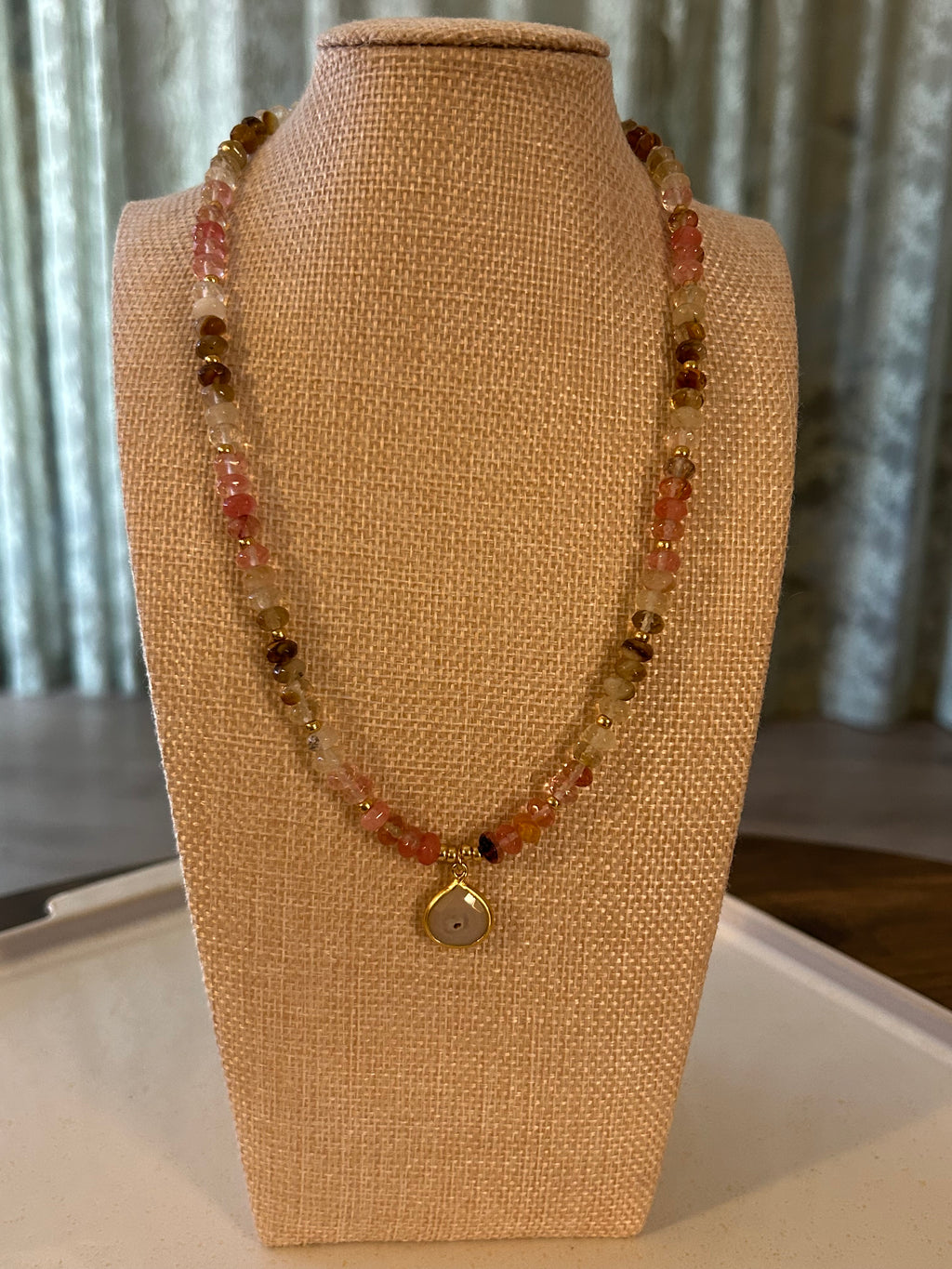 Beaded necklace on a mannequin bust with a neutral background