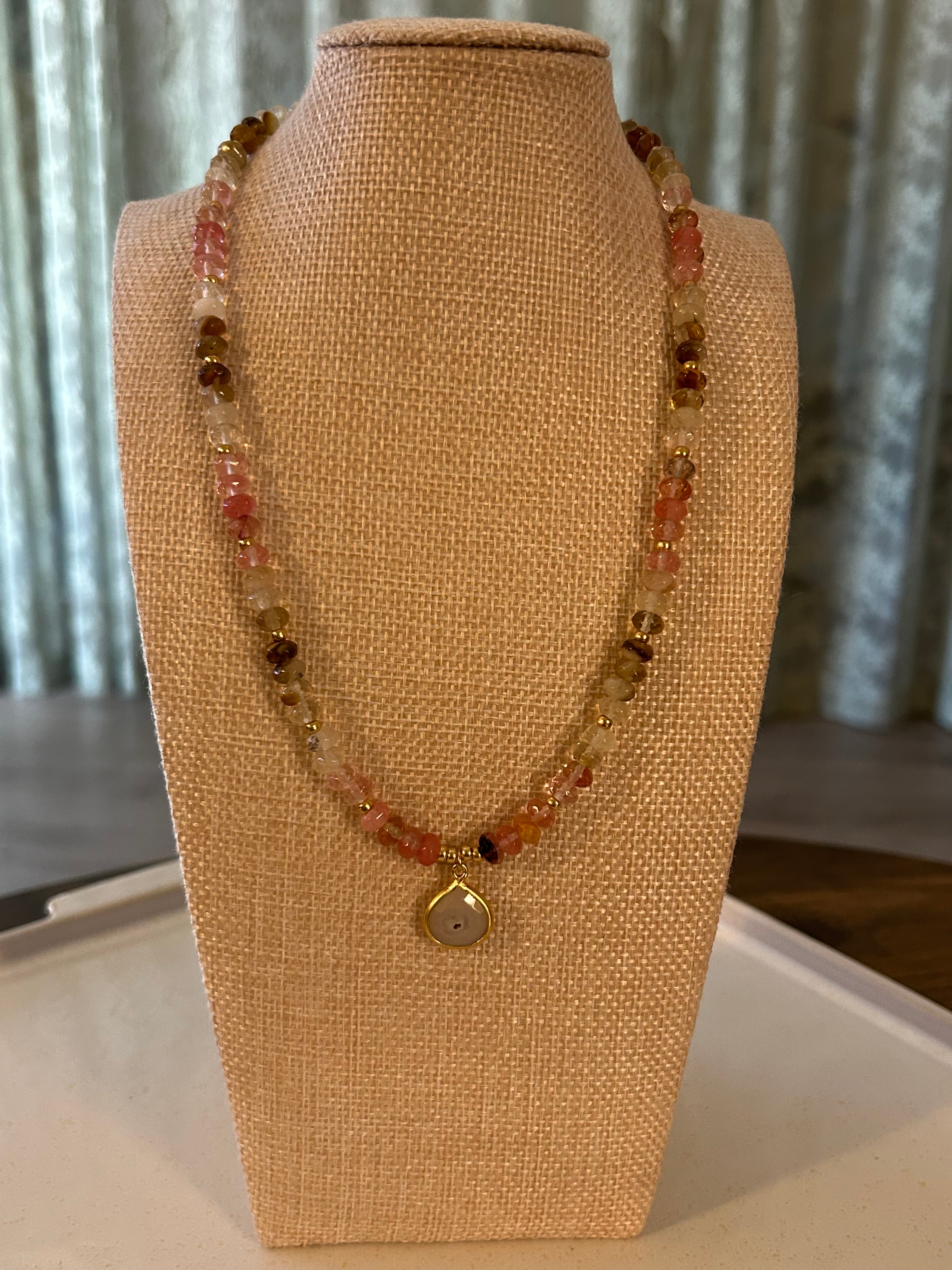 Beaded necklace on a mannequin bust with a neutral background