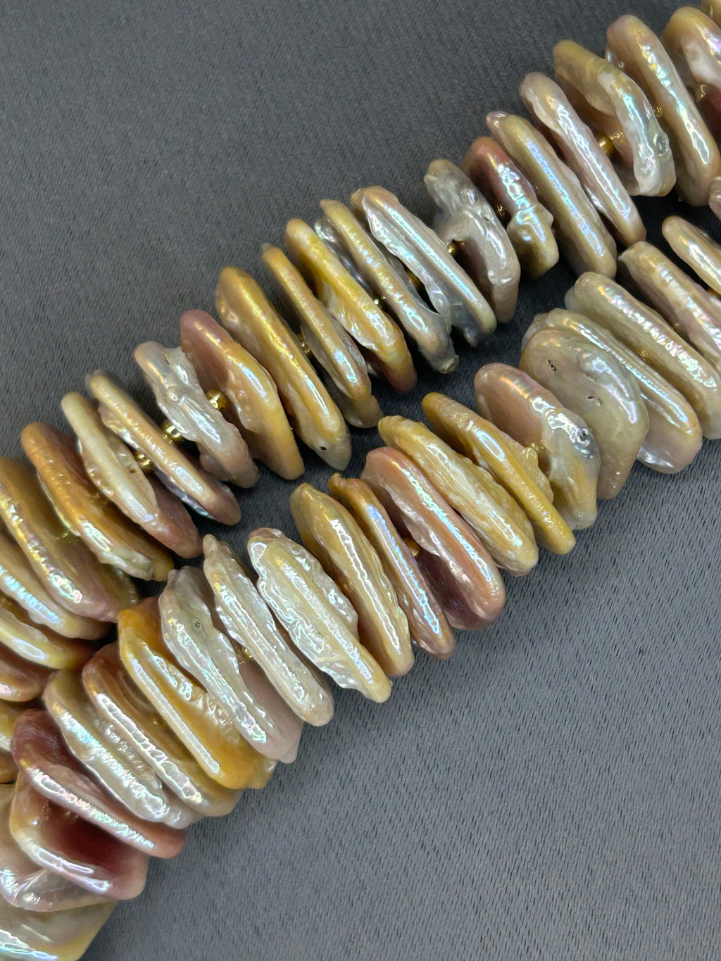 Close-up of a strand of shell beads on a gray background