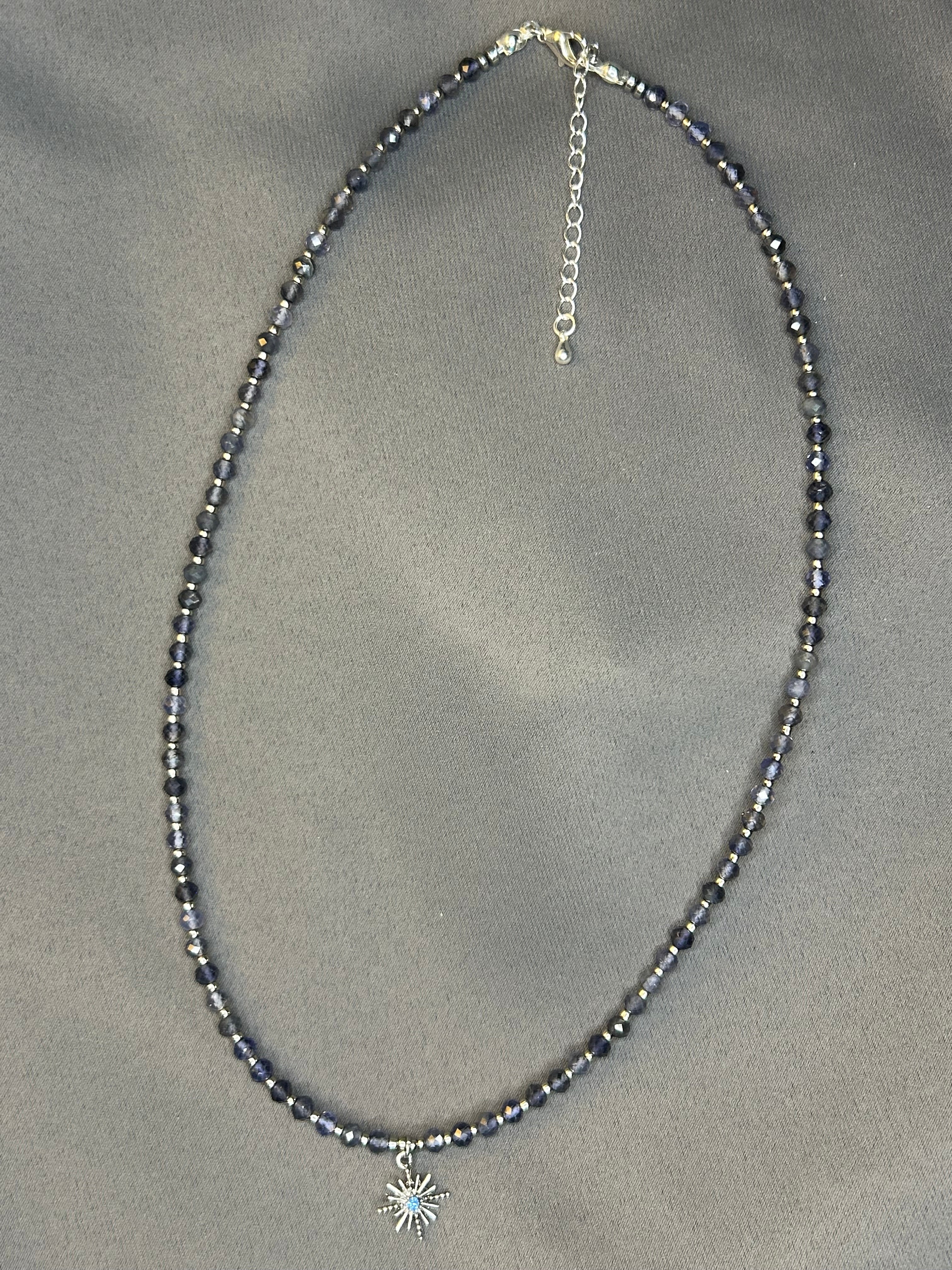 Necklace with blue beads on a gray fabric background