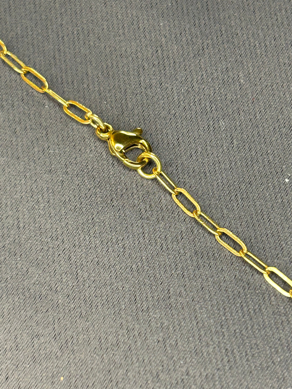 Gold chain with a clasp on a gray background