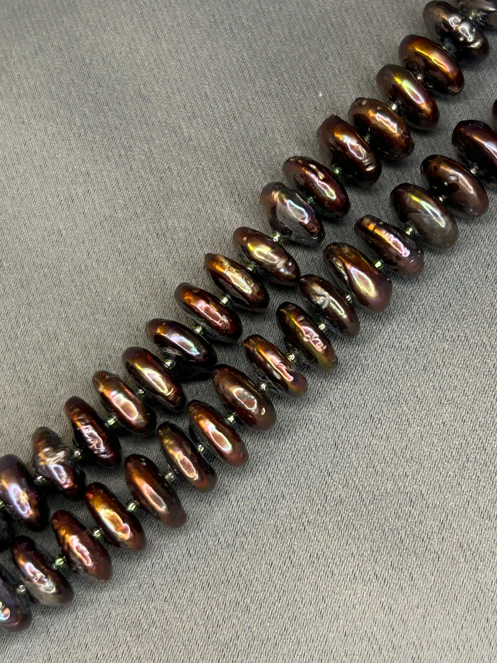 Row of brown pearl beads on a gray surface
