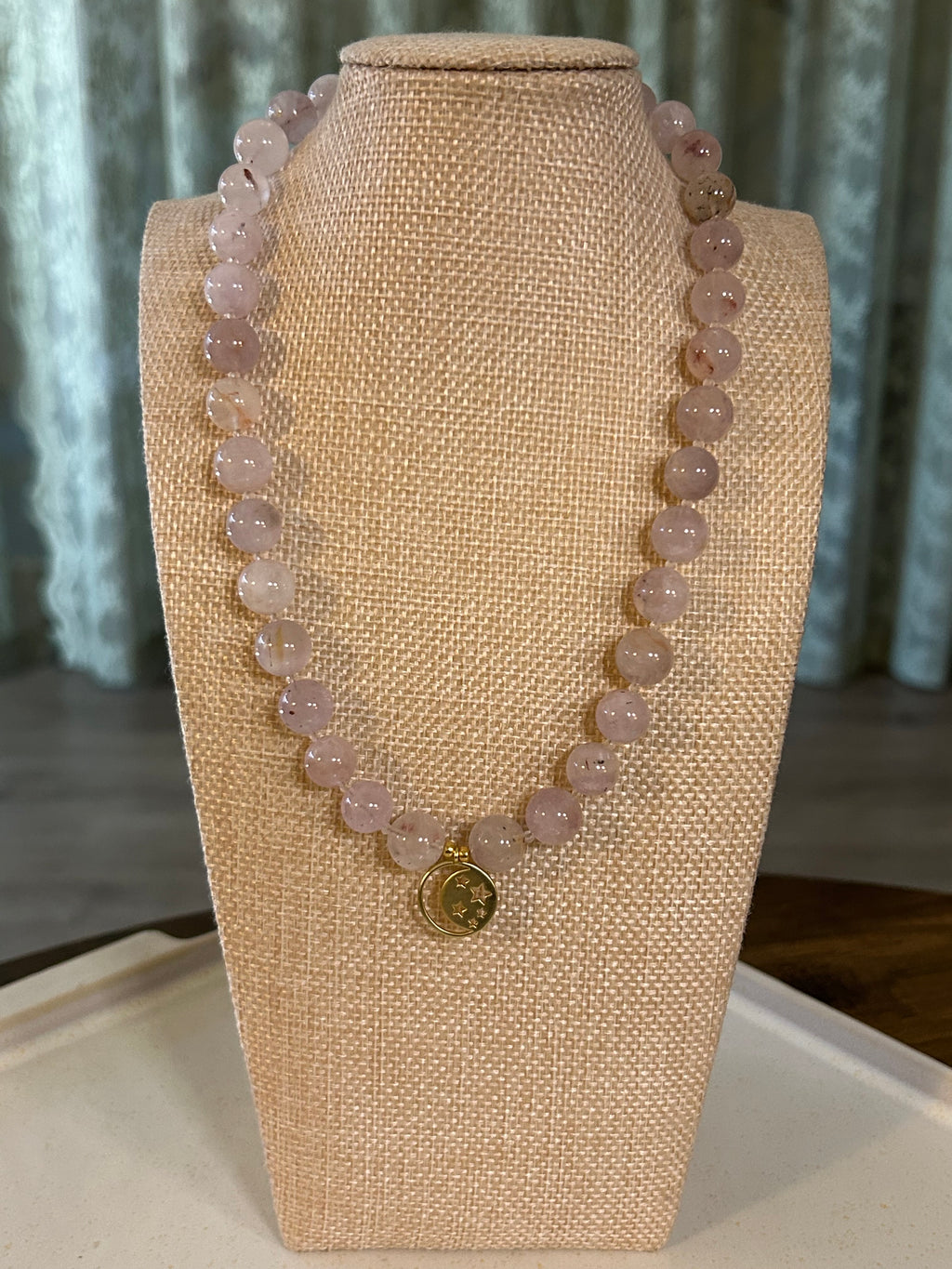 Purple clear beaded necklace on a mannequin bust with a neutral background