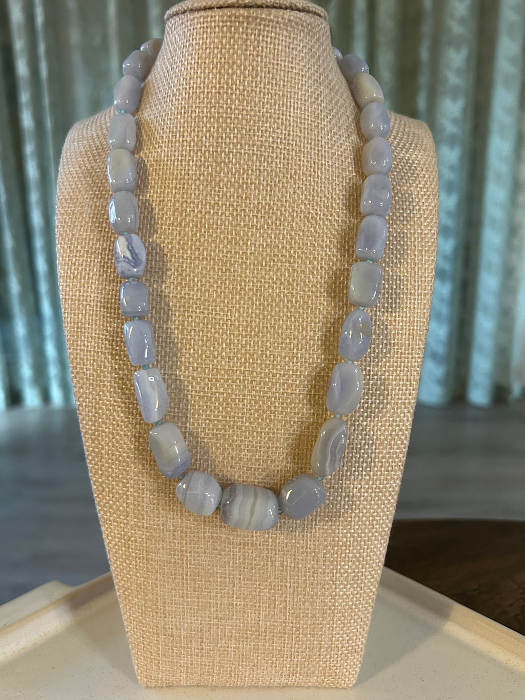 Blue beaded bracelet on a beige display