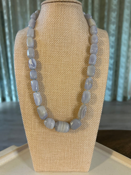 Blue beaded bracelet on a beige display