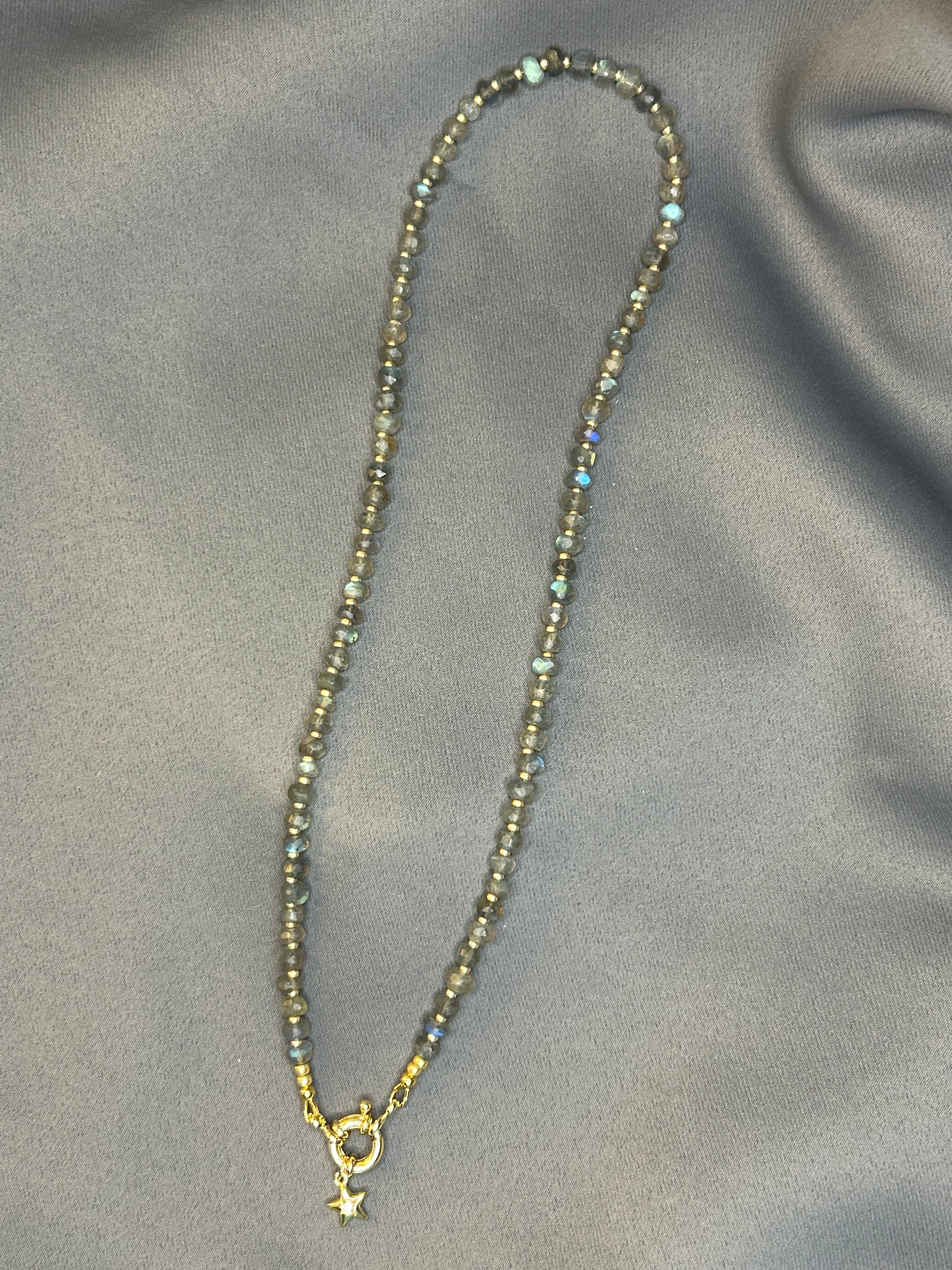 Necklace with gray beads on a gray fabric background