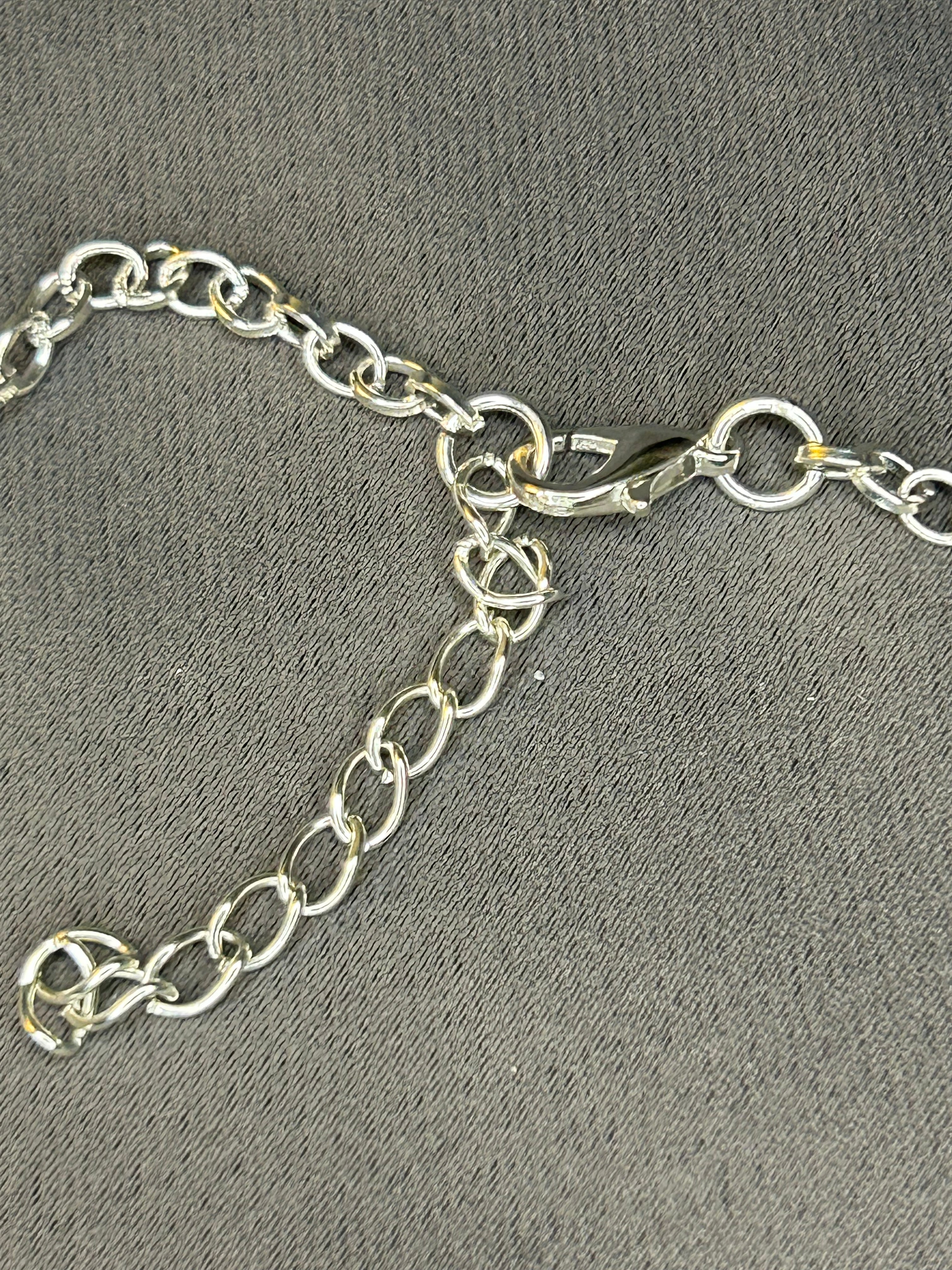 Silver chain with a clasp on a gray textured background