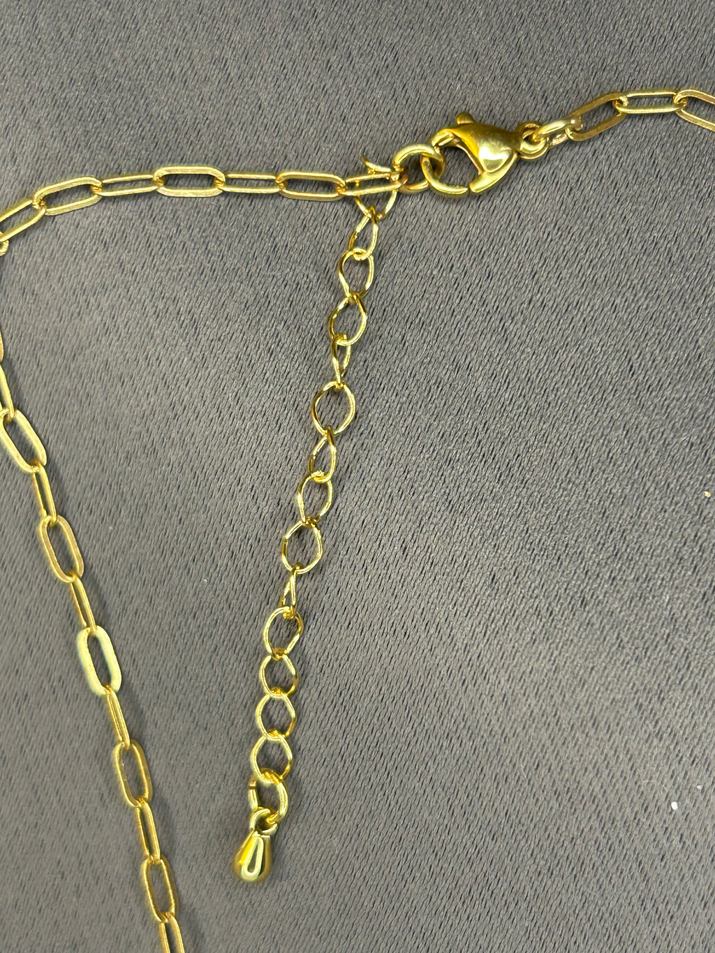 Gold chain necklace on a gray background