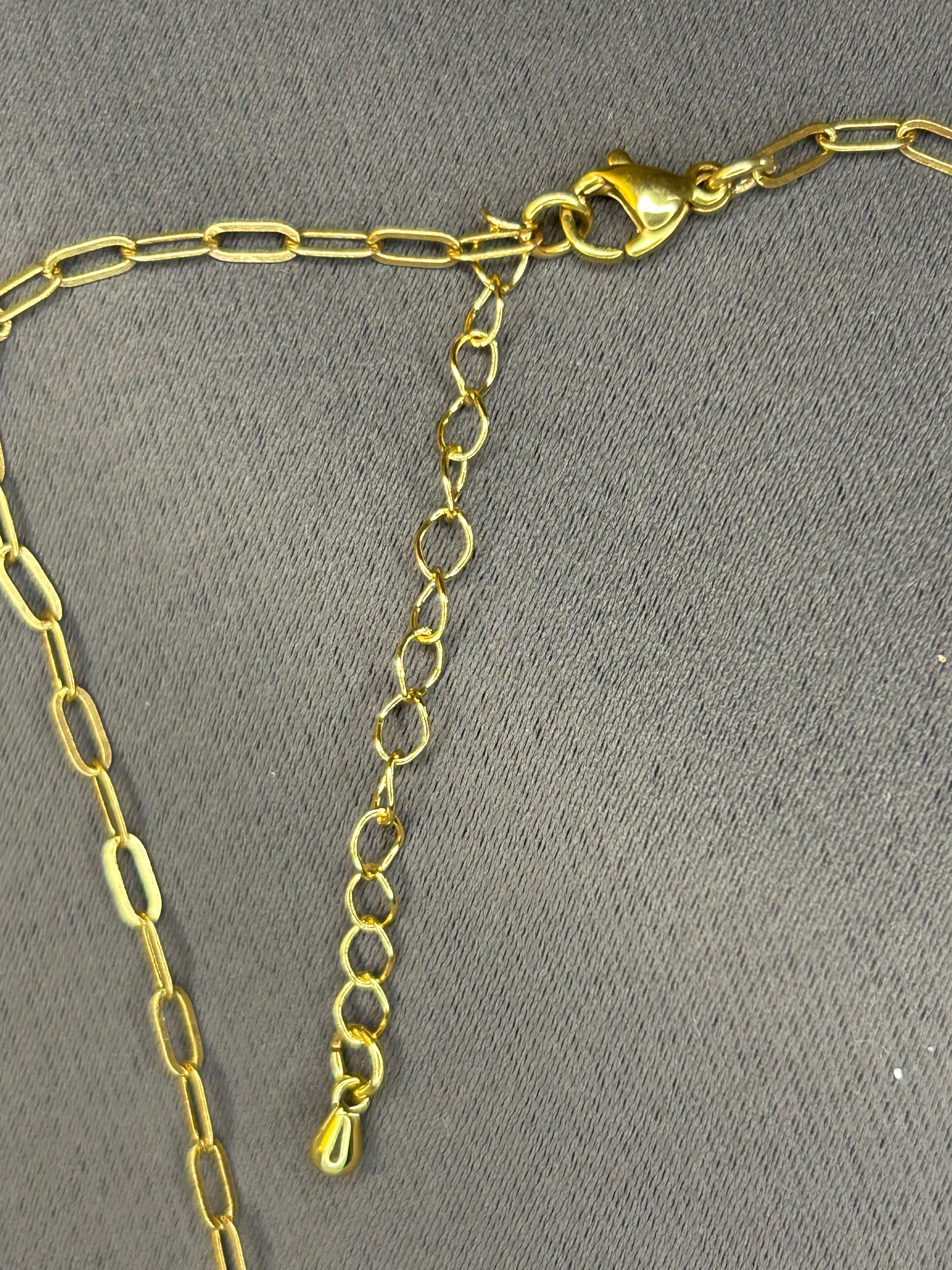 Gold chain necklace on a gray background