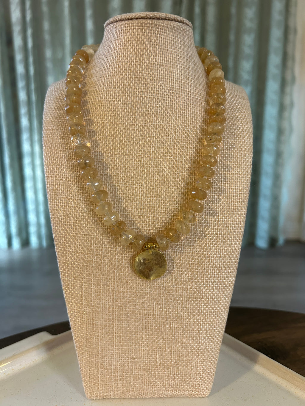 Gold necklace on a beige jewelry display