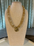 Gold necklace on a beige jewelry display