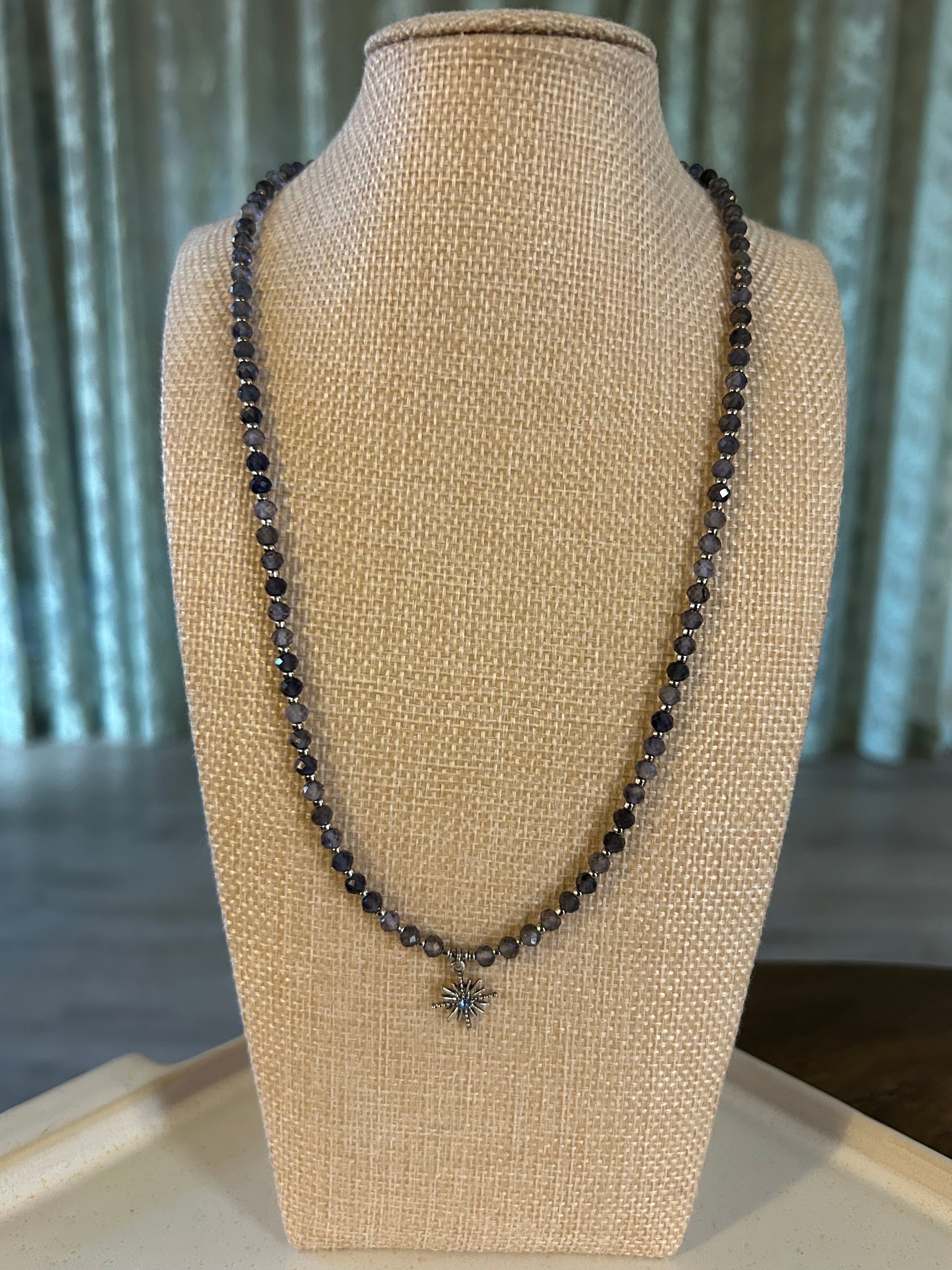 Necklace on a mannequin bust with a neutral background