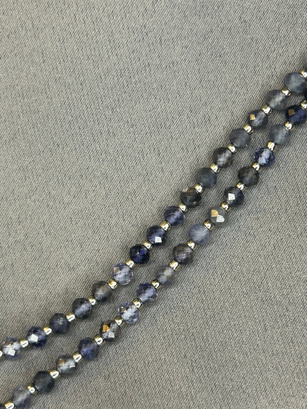 Necklace with blue beads on a gray fabric background