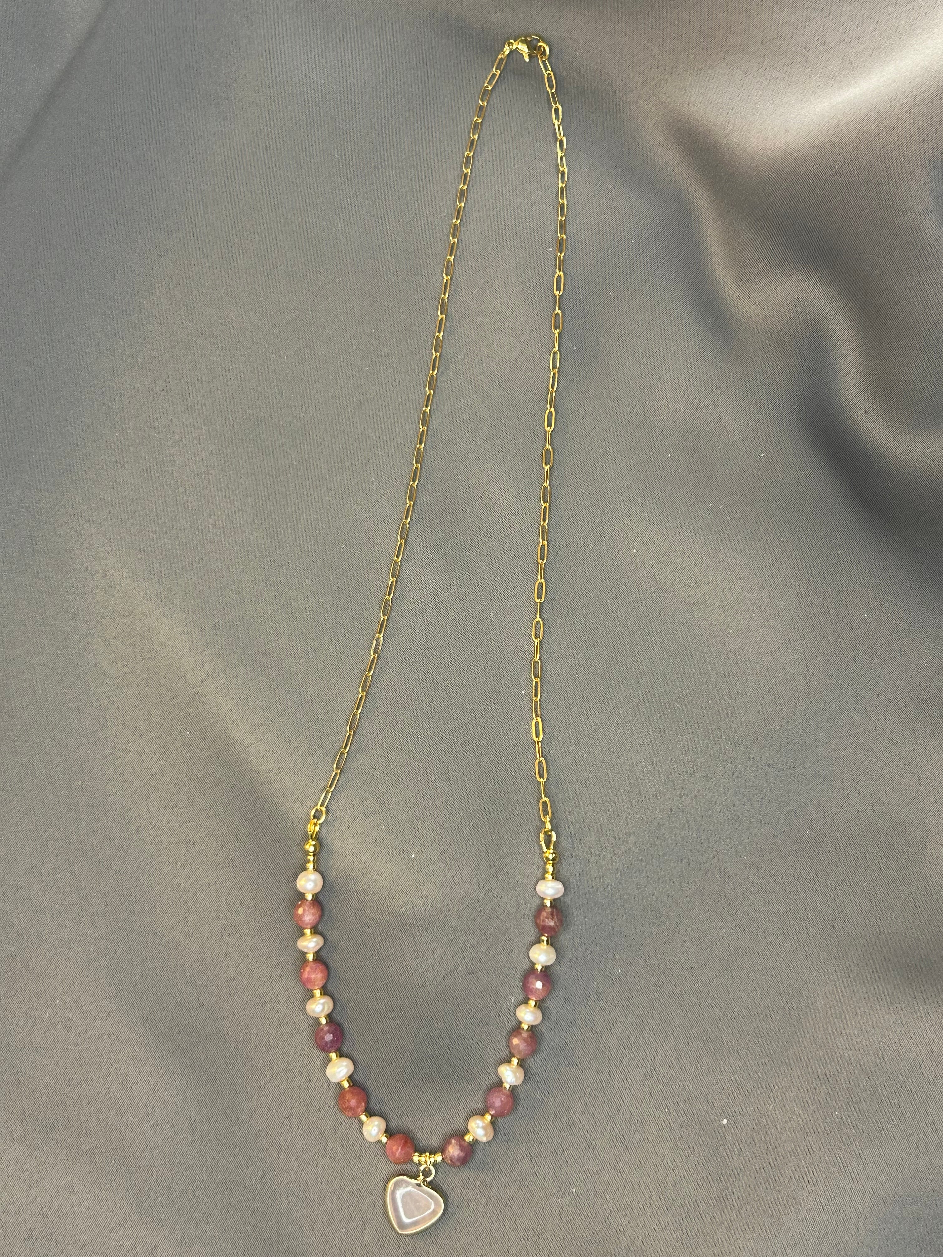 Necklace with heart-shaped pendant on a gray fabric background