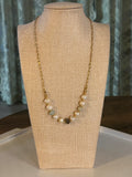 Pearl necklace on a mannequin bust with a neutral background