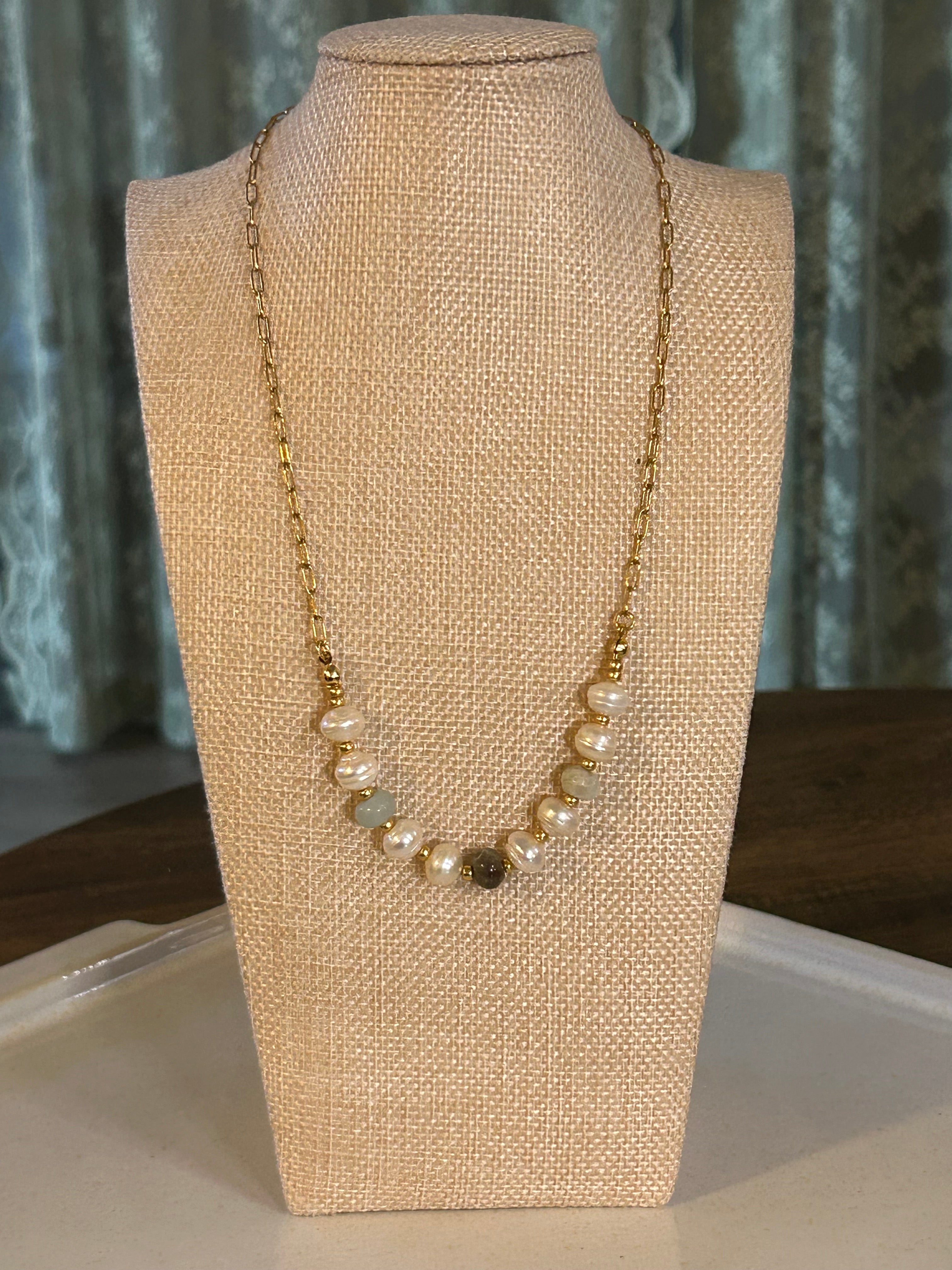 Pearl necklace on a mannequin bust with a neutral background