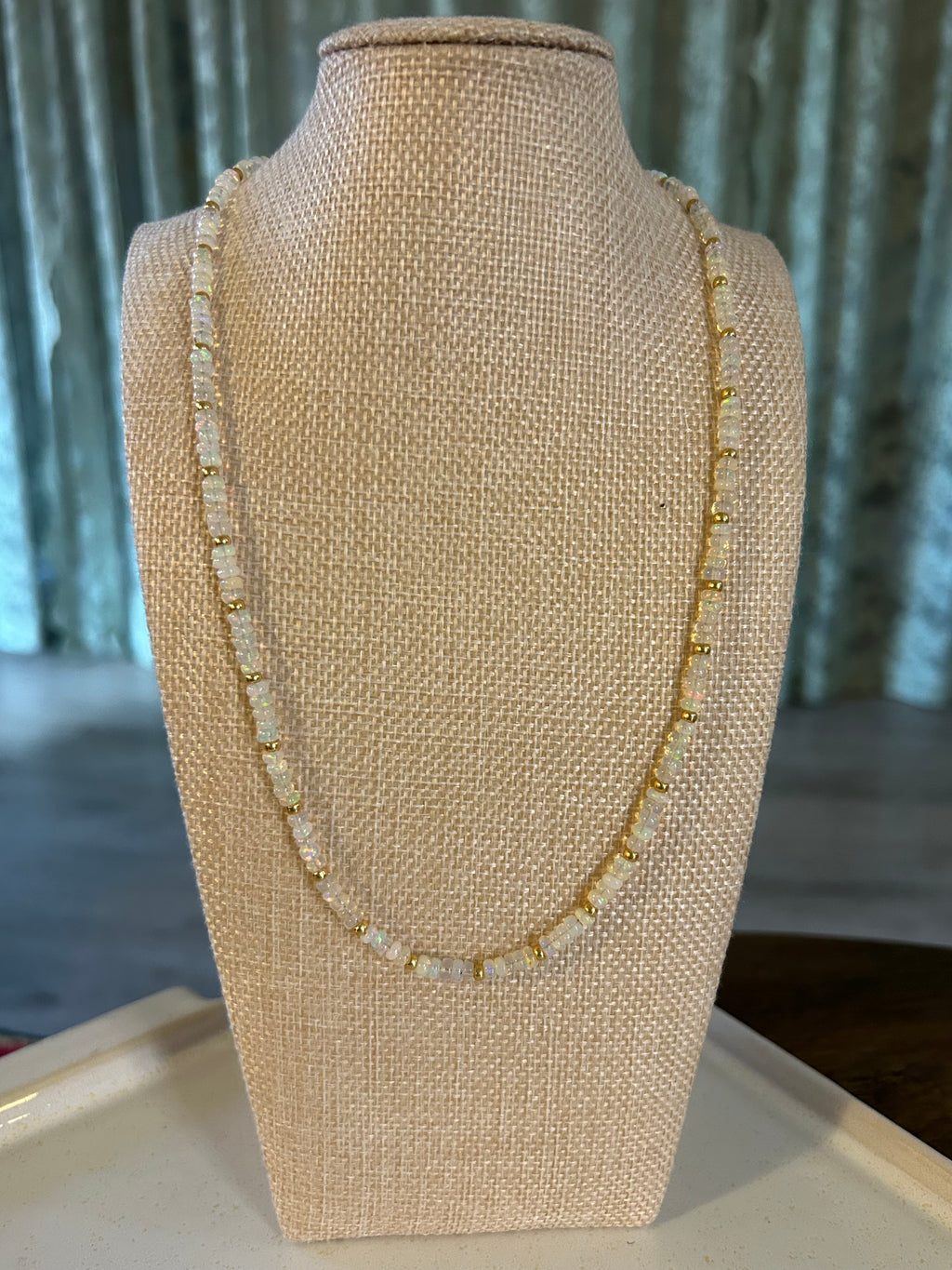 Opal beaded necklace on a beige mannequin arm