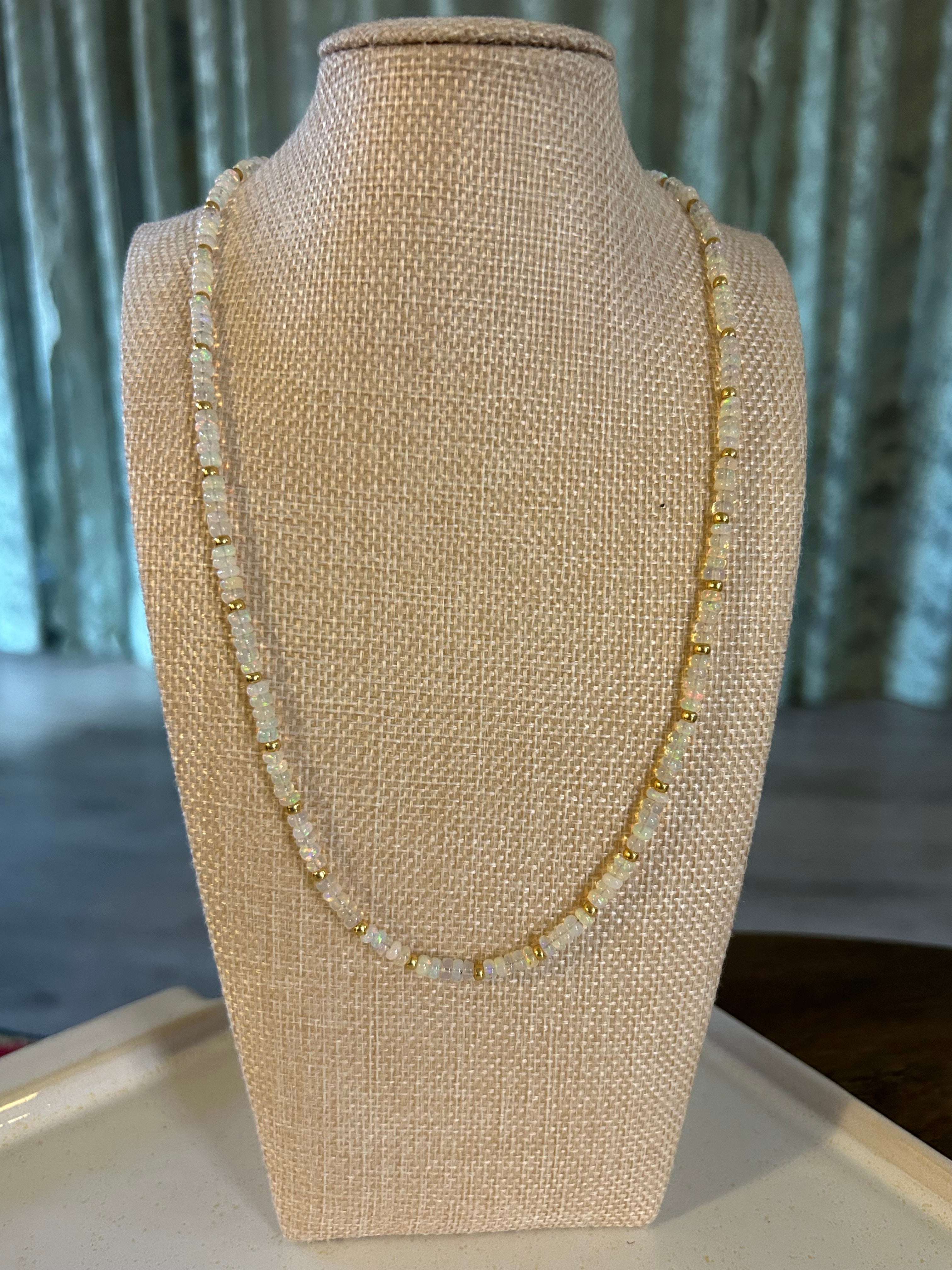 Opal beaded necklace on a beige mannequin arm