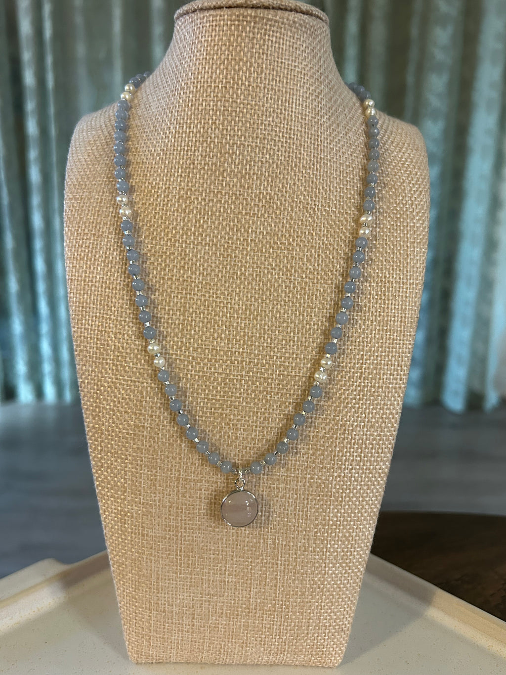 Necklace on a beige jewelry display with a blurred background